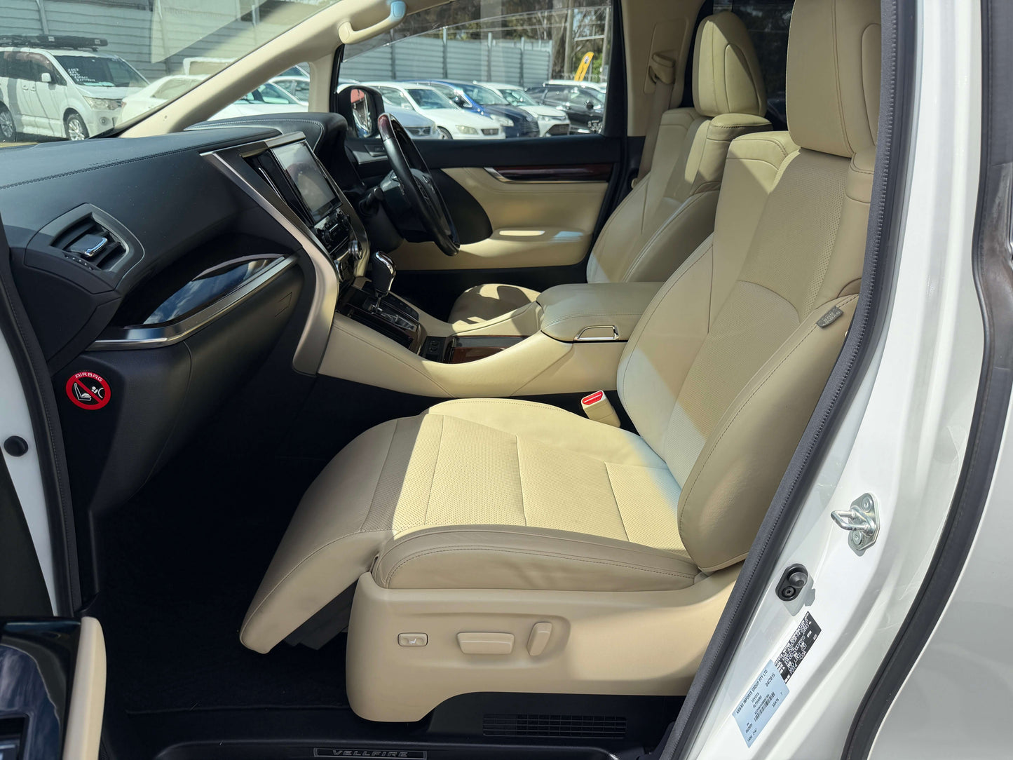 Interior view of the 2015 Toyota Vellfire 2.5L e-Four Hybrid V-L Edition showing spacious beige seats.