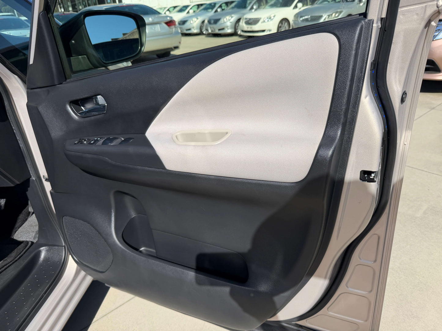 Interior view of the 2017 Nissan Serena 2.0L S-Hybrid door panel with controls and upholstery.
