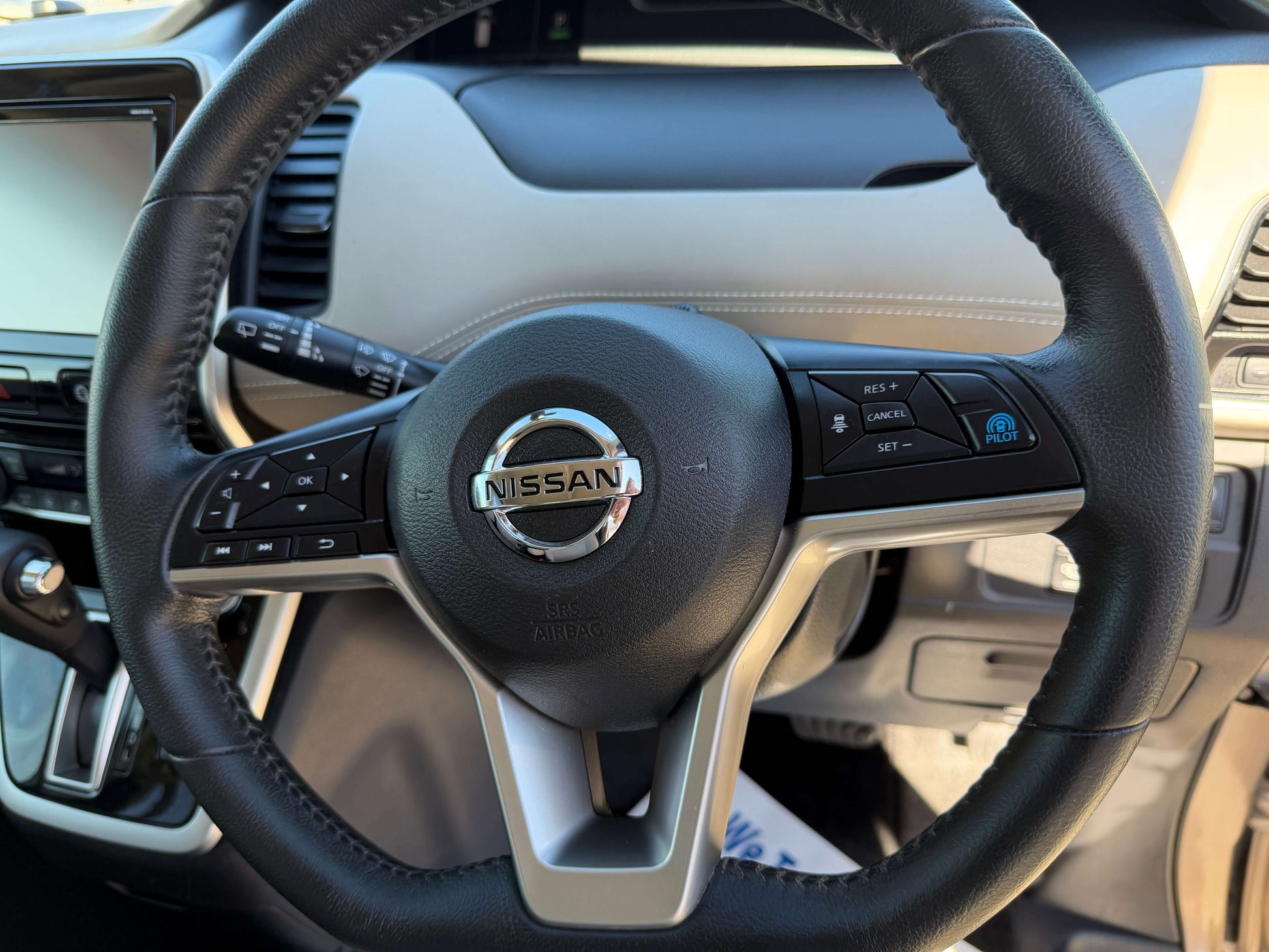 Interior view of the 2017 Nissan Serena 2.0L S-Hybrid steering wheel with controls and Nissan logo.