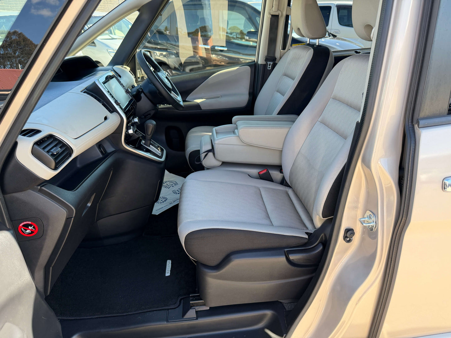 Interior view of 2017 Nissan Serena 2.0L S-Hybrid showing spacious front seats and console.