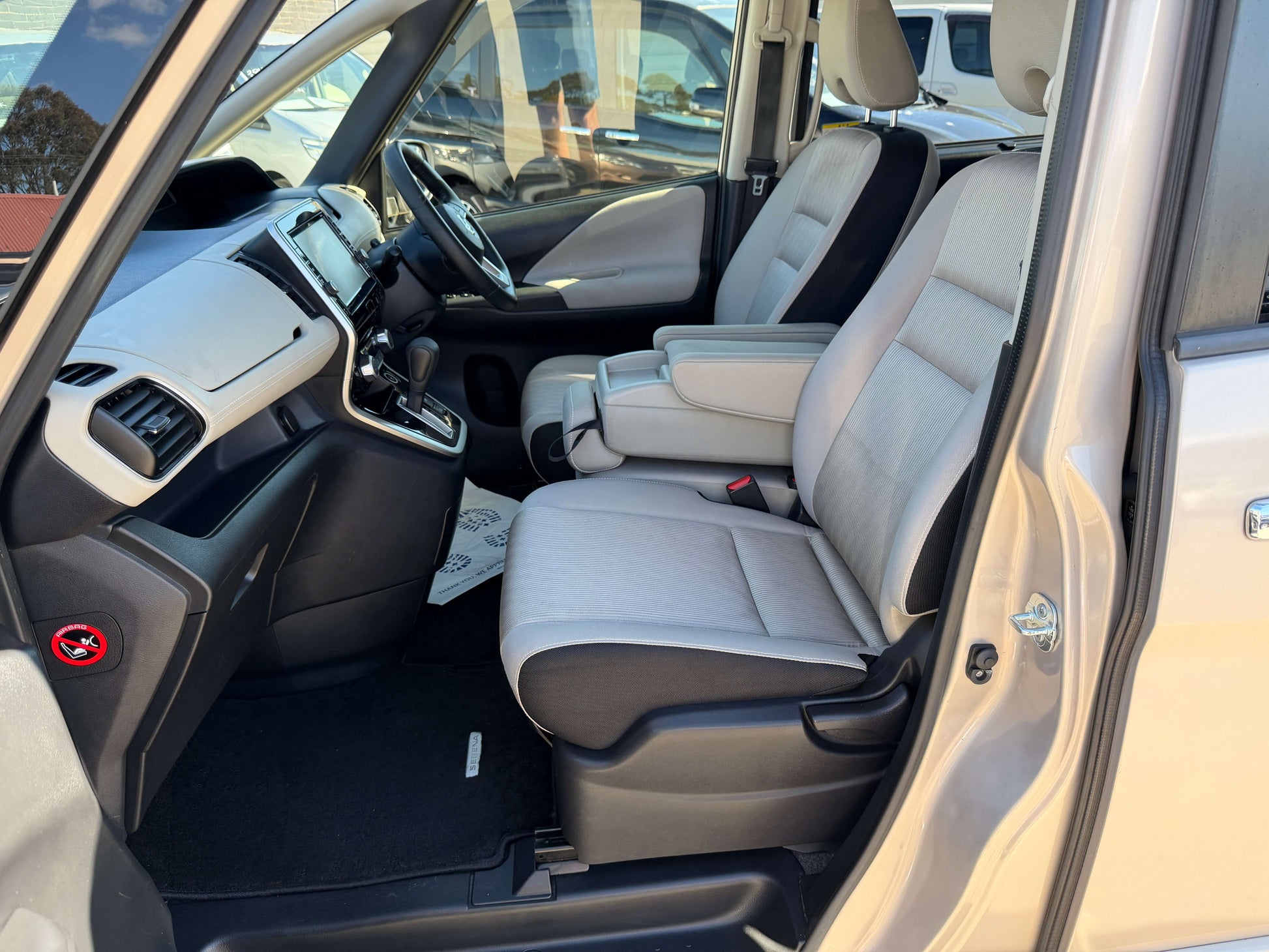 Interior view of 2017 Nissan Serena 2.0L S-Hybrid showing spacious front seats and console.