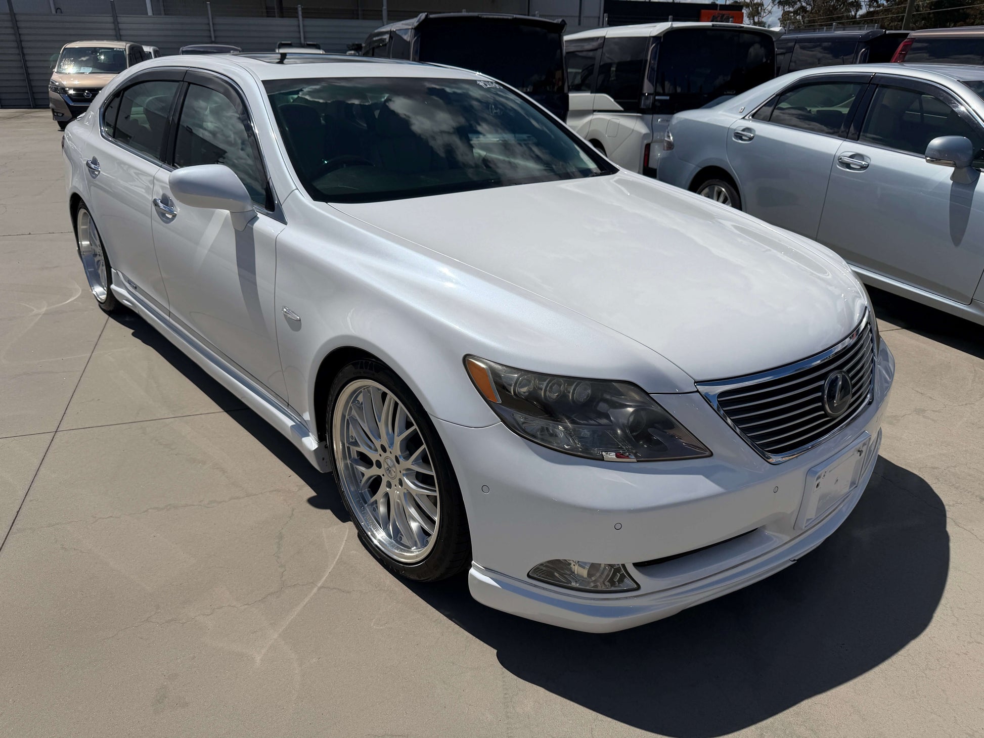 2007 Lexus LS600hL AWD V8 5.0L Hybrid Luxury Sedan in white parked outside.