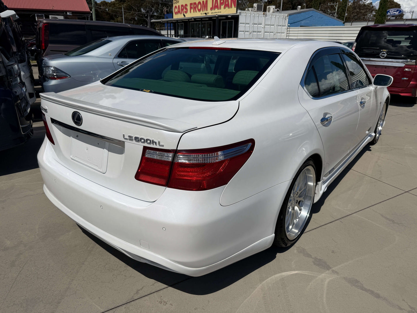 2007 Lexus LS600hL AWD V8 5.0L Hybrid Luxury Sedan rear view in white with clear sky background.