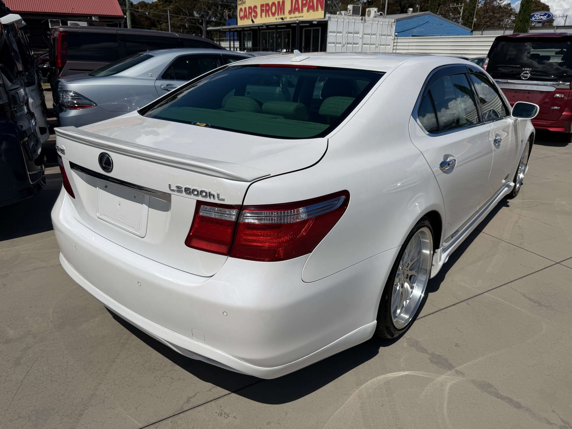 2007 Lexus LS600hL AWD V8 5.0L Hybrid Luxury Sedan rear view in white with clear sky background.