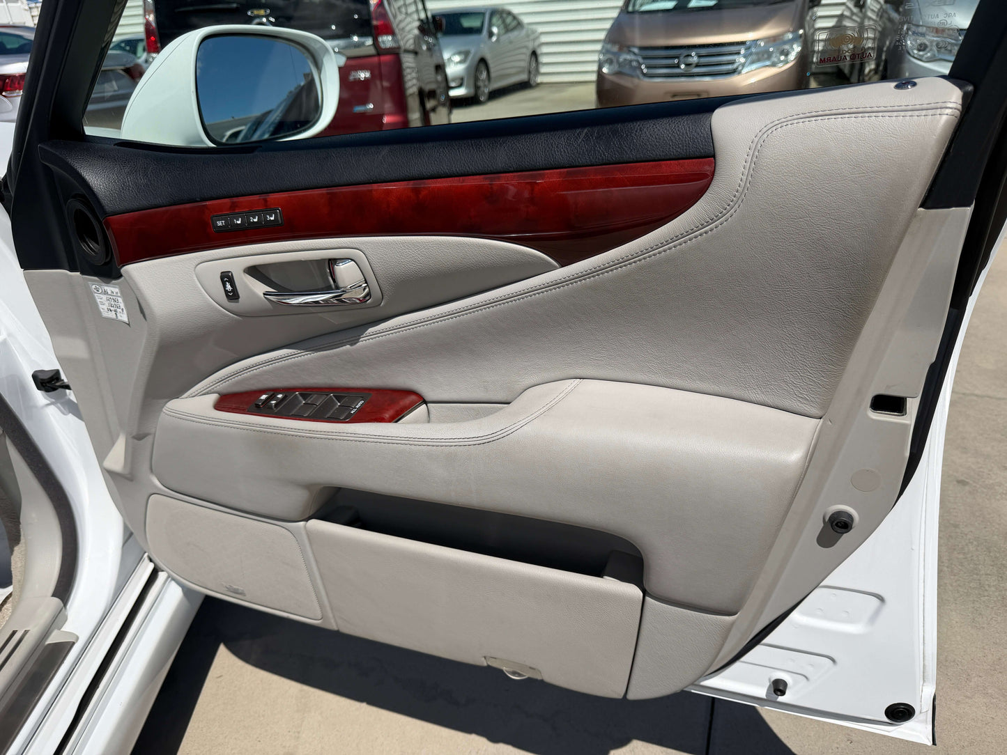 Interior door panel of a 2007 Lexus LS600hL AWD V8 5.0L Hybrid, showcasing luxury features and leather trim.