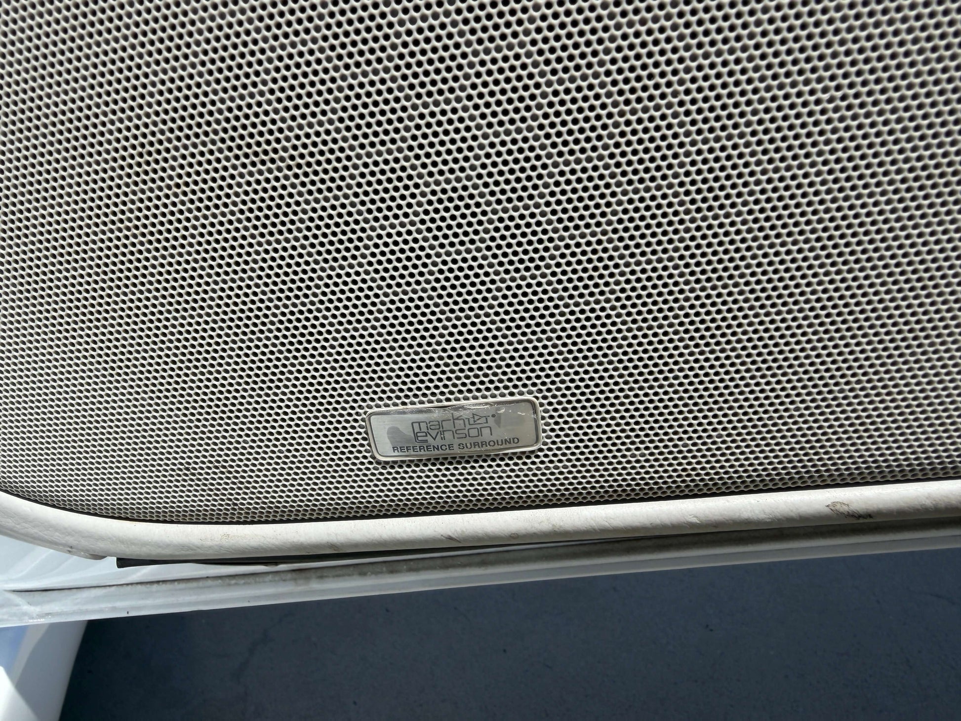 2007 Lexus LS600hL AWD V8 5.0L Hybrid Close-up of a metal label on a mesh speaker grill, showing detailed texture and design.