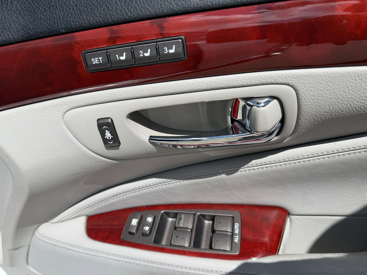 Interior door panel controls of a 2007 Lexus LS600hL AWD V8 5.0L Hybrid Luxury Sedan, featuring power window and seat adjustments.