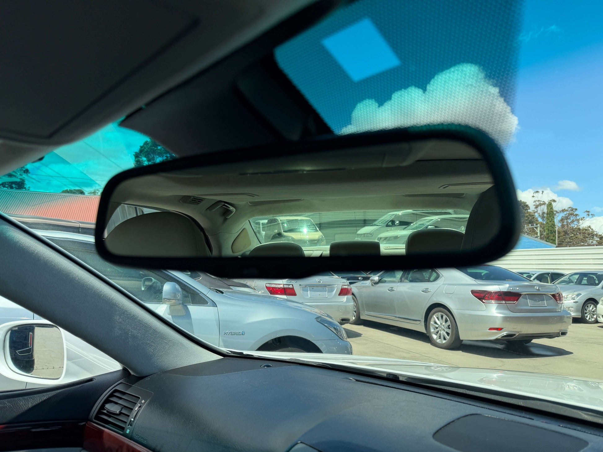 2007 Lexus LS600hL AWD V8 5.0L Hybrid Interior view of a car's rearview mirror with reflections of parked vehicles in the background.
