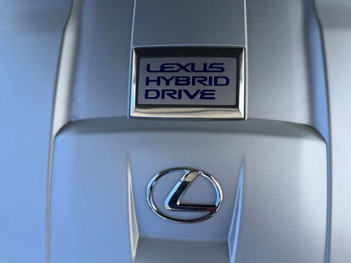 2007 Lexus LS600hL AWD V8 5.0L Hybrid Lexus Hybrid Drive emblem on the engine cover of a luxury vehicle.