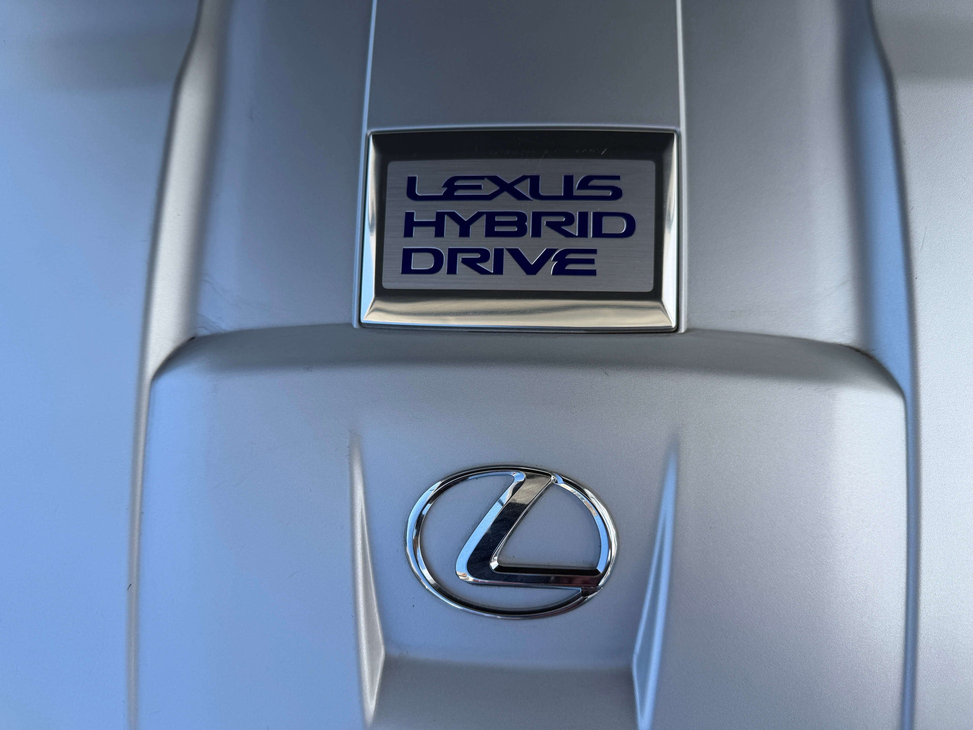 2007 Lexus LS600hL AWD V8 5.0L Hybrid Lexus Hybrid Drive emblem on the engine cover of a luxury vehicle.