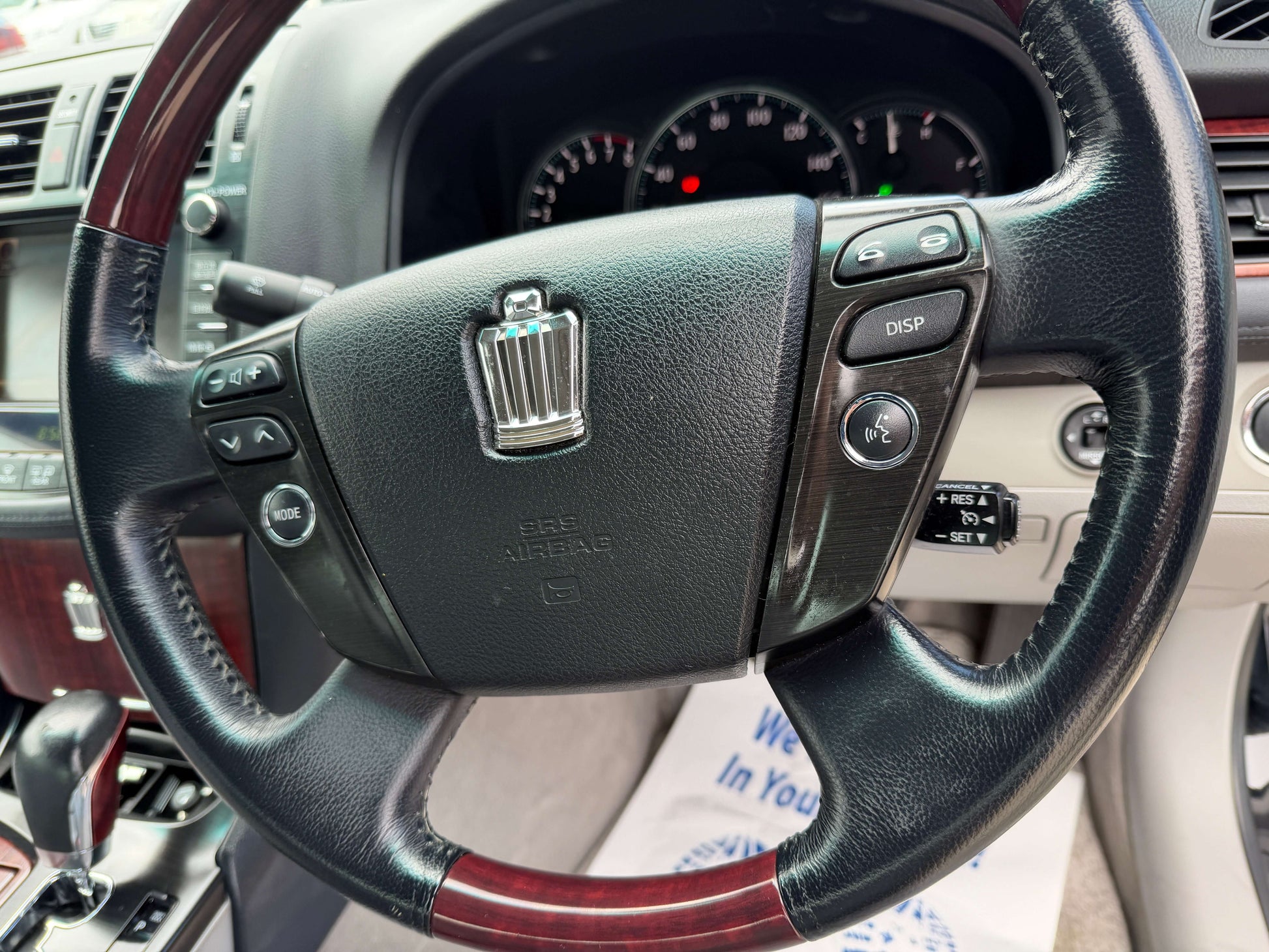 2008 Toyota Crown V6 3.0L steering wheel with wood trim and control buttons, showcasing luxury interior features.