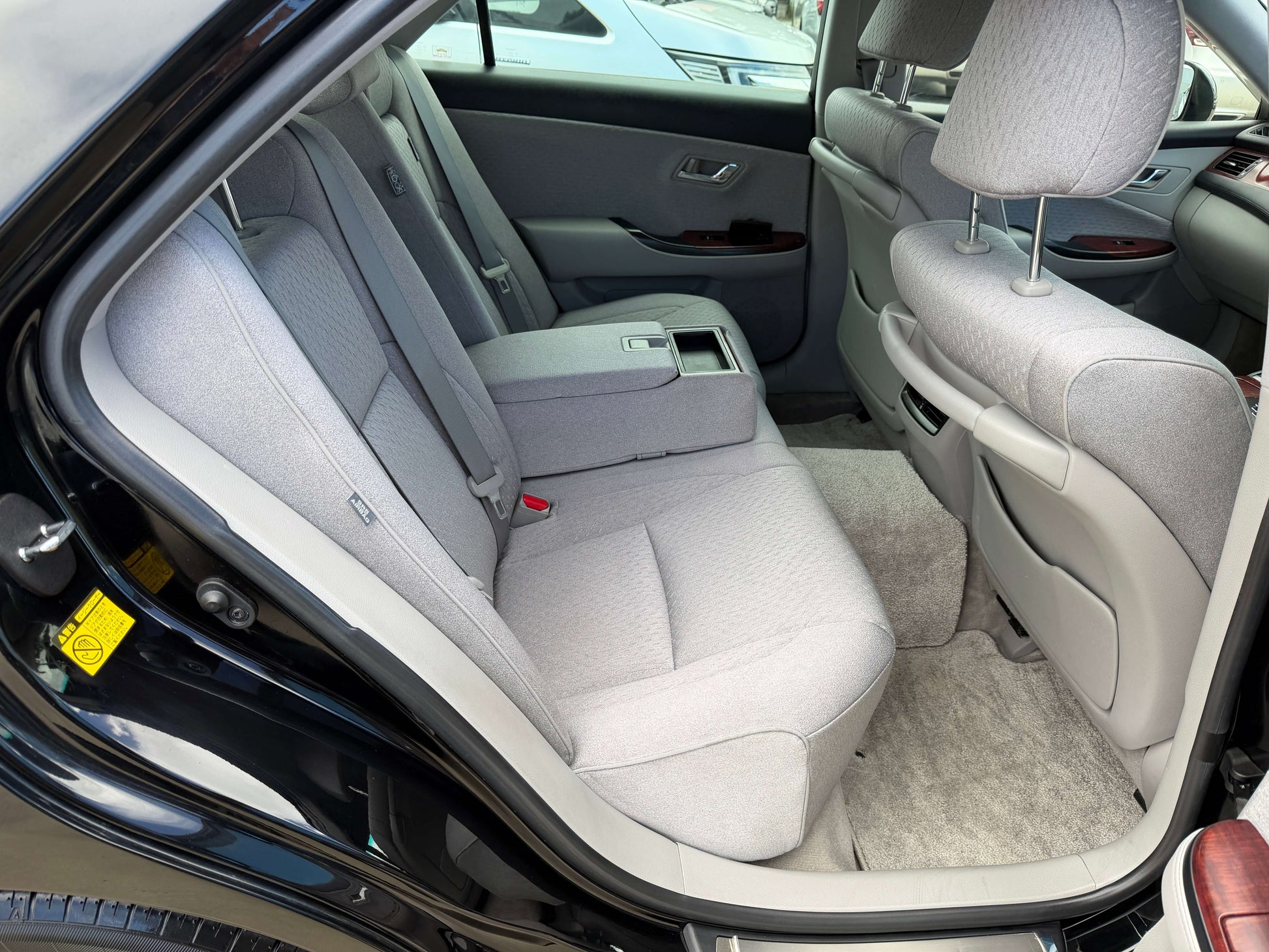 Interior view of the back seats in a 2008 Toyota Crown V6 3.0L Royal Saloon Edition Luxury Sedan, featuring plush light-grey upholstery.