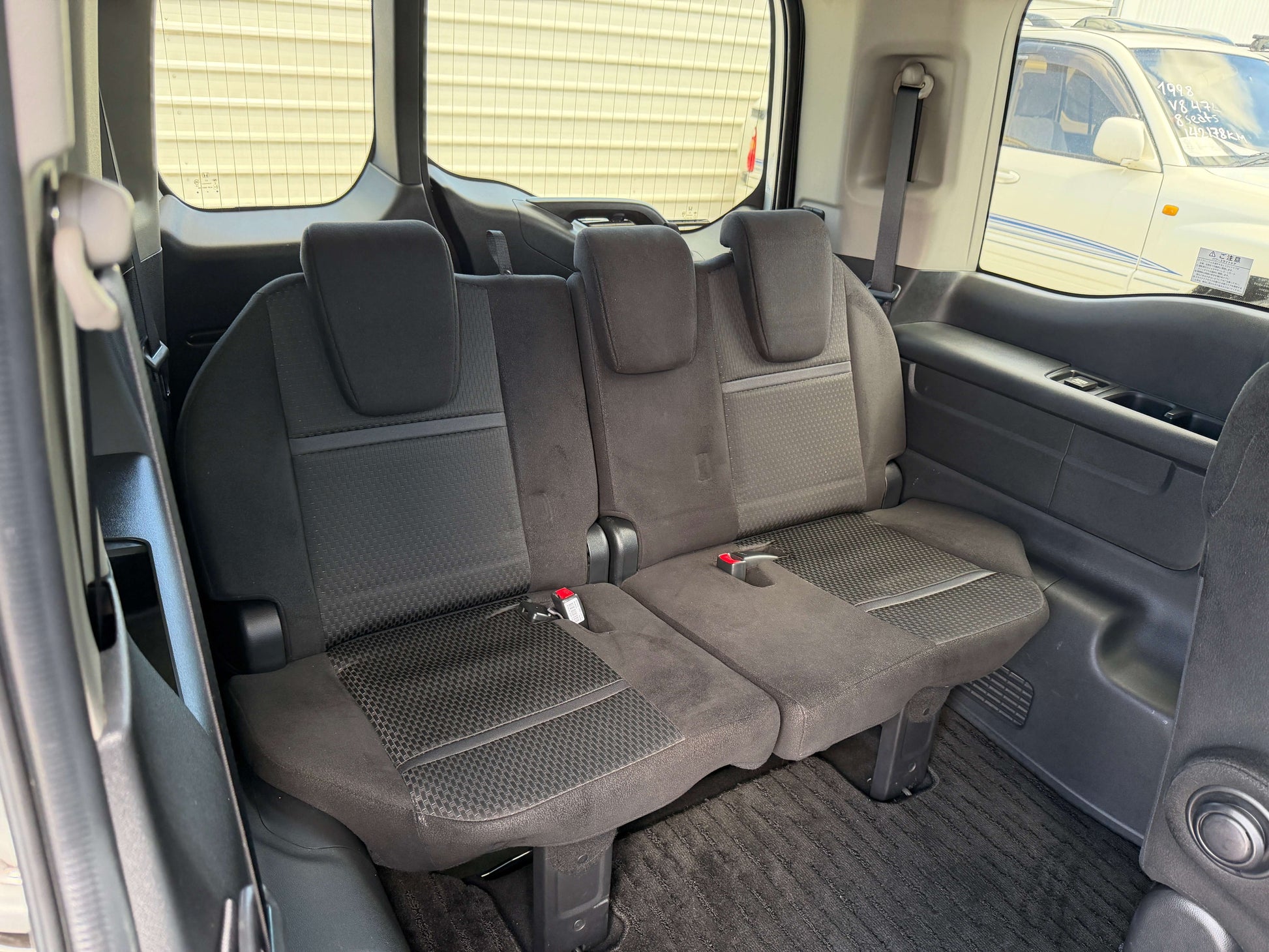 Interior view of the rear seats in the 2019 Honda Honda Stepwgn 2.0 Spada Hybrid, featuring spacious seating for passengers.