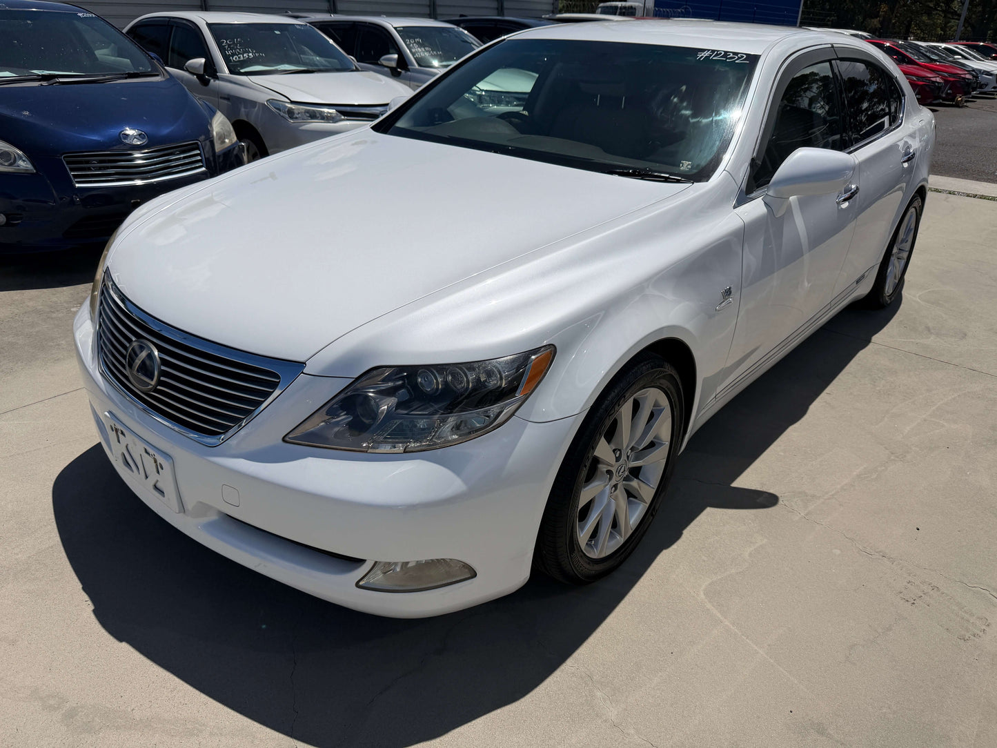 2007 Lexus LS600h AWD V8 5.0L Hybrid Luxury Sedan in pearl white color parked outdoors.