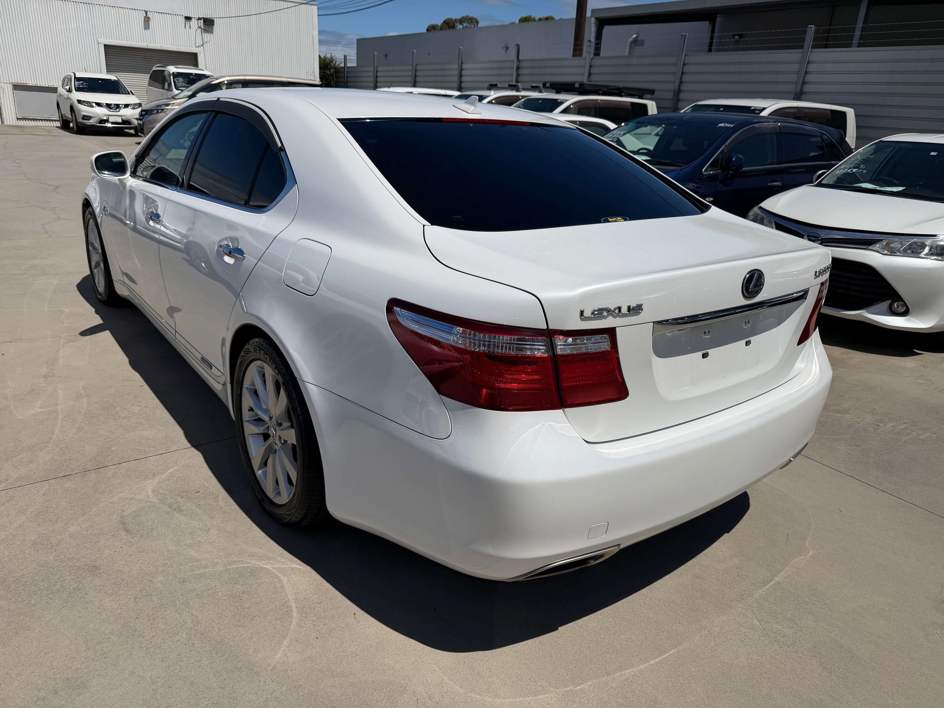 2007 Lexus LS600h AWD V8 5.0L Hybrid luxury sedan in pearl white parked.