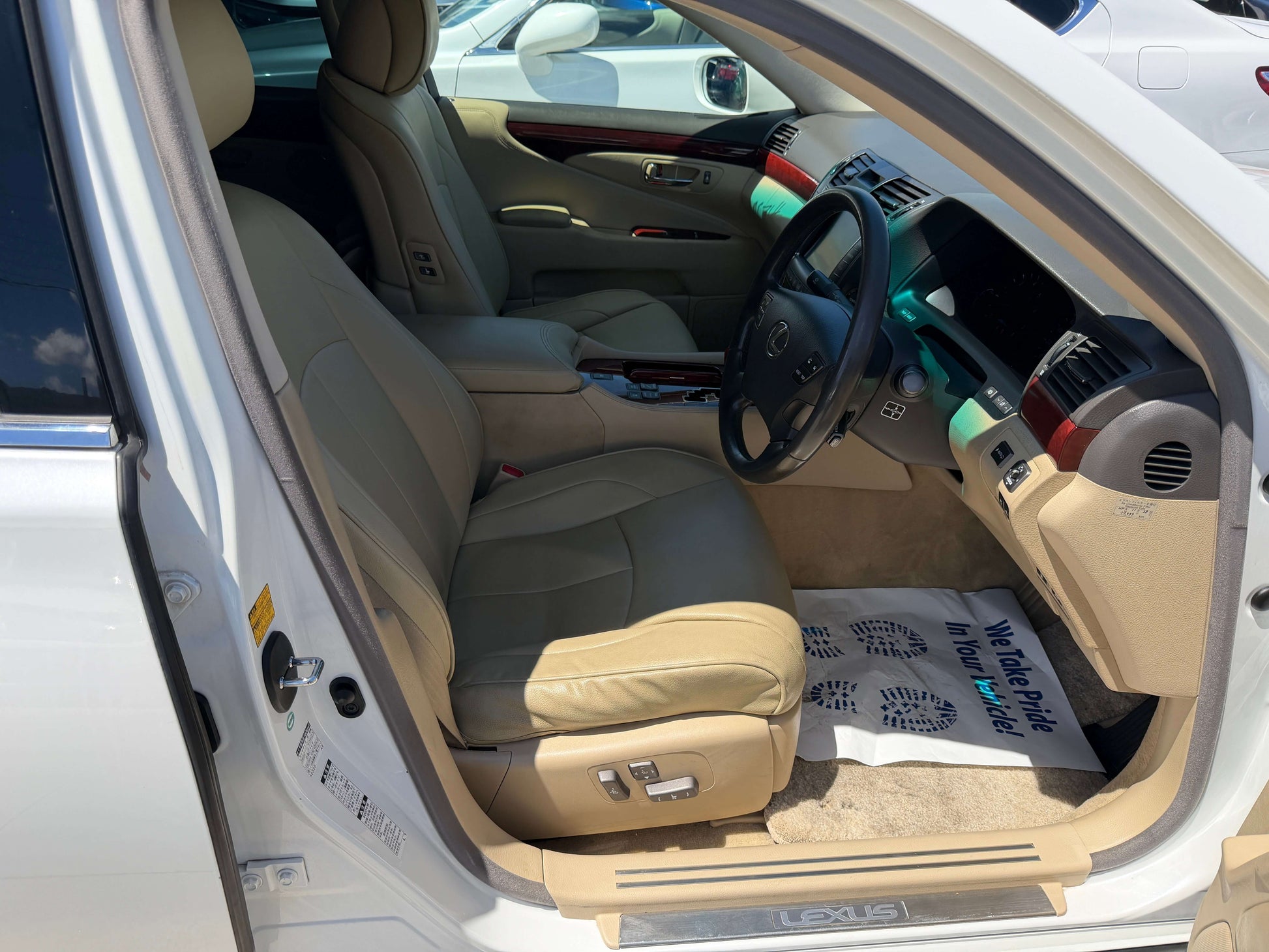 Interior view of 2007 Lexus LS600h AWD V8 5.0L Hybrid showing tan leather seats and dashboard features.