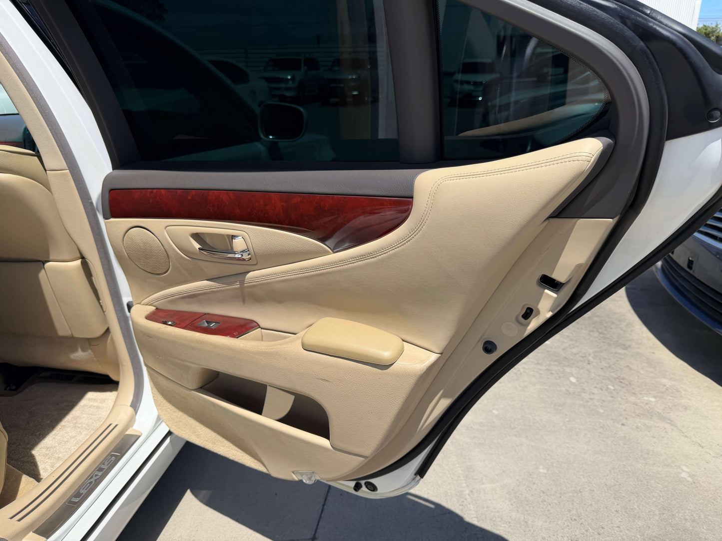 Interior view of the door panel of a 2007 Lexus LS600h AWD V8 5.0L Hybrid Luxury Sedan, featuring leather trim and wood accents.