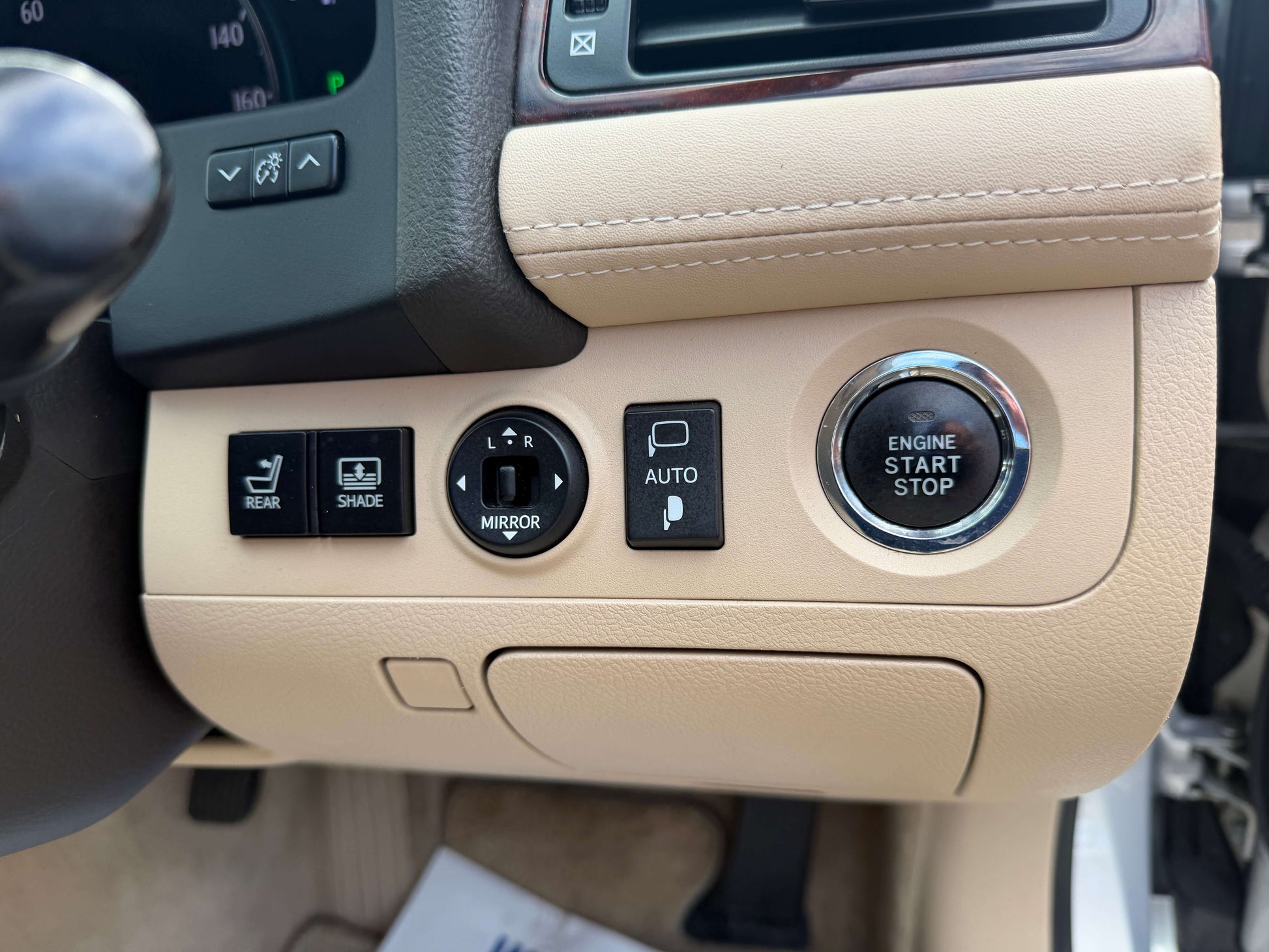 Interior controls of the 2010 Toyota Crown V6 3.0L, featuring button panel and engine start/stop button.