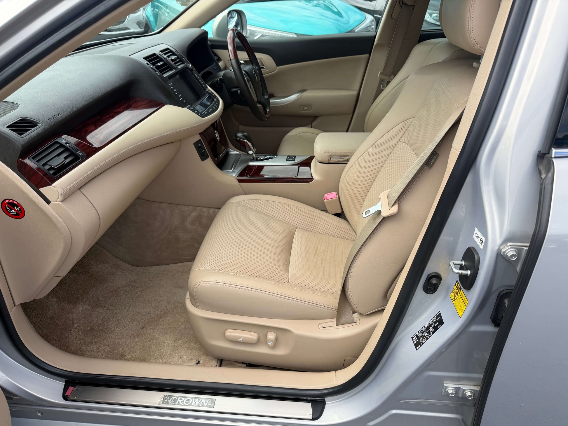 Interior view of the 2010 Toyota Crown V6 3.0L Royal Saloon G Edition luxury sedan with beige leather seats.