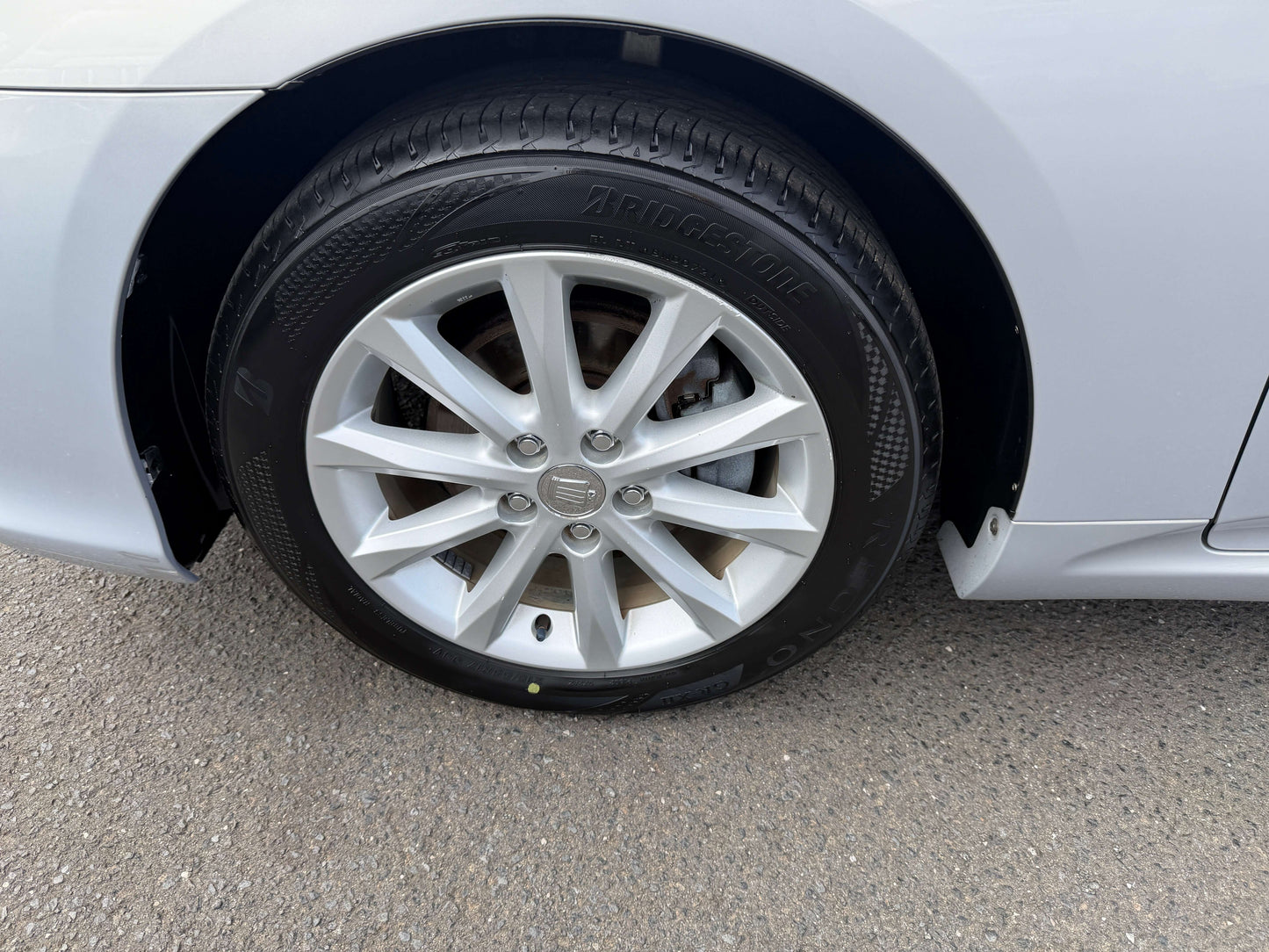 Close-up of the wheel and tire of a 2010 Toyota Crown V6 3.0L Royal Saloon G Edition luxury sedan.