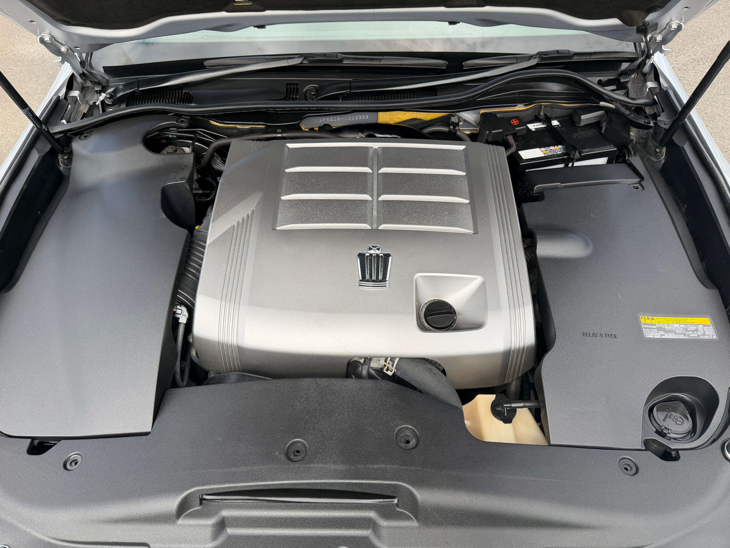 Engine compartment of a 2010 Toyota Crown V6 3.0L showing the powerful engine and components.
