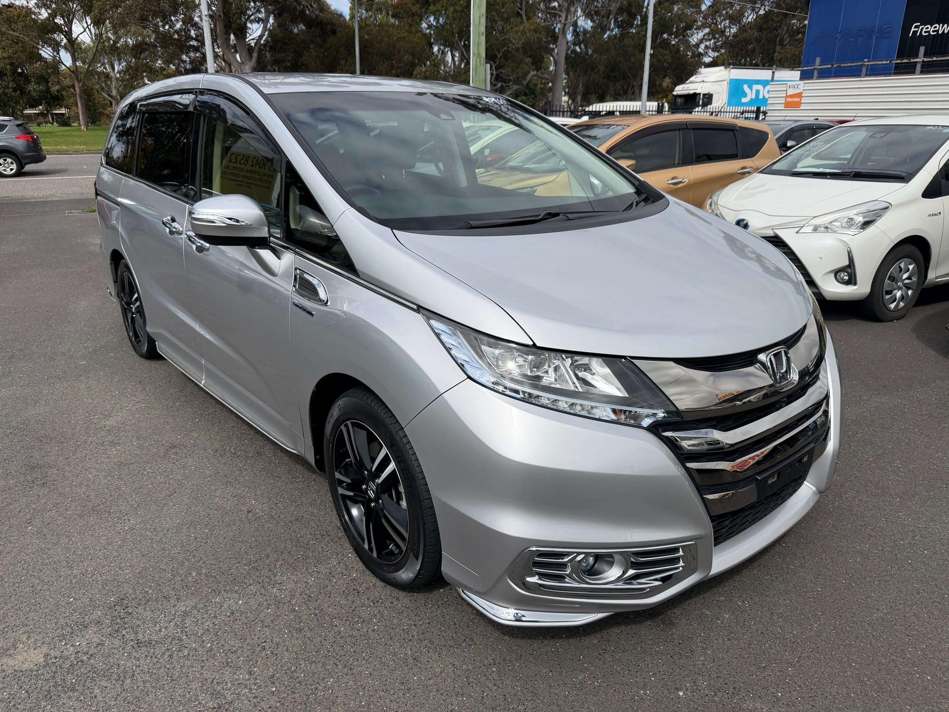 2016 Honda Odyssey 2.0 Hybrid in silver color parked, displaying sleek design and modern features.