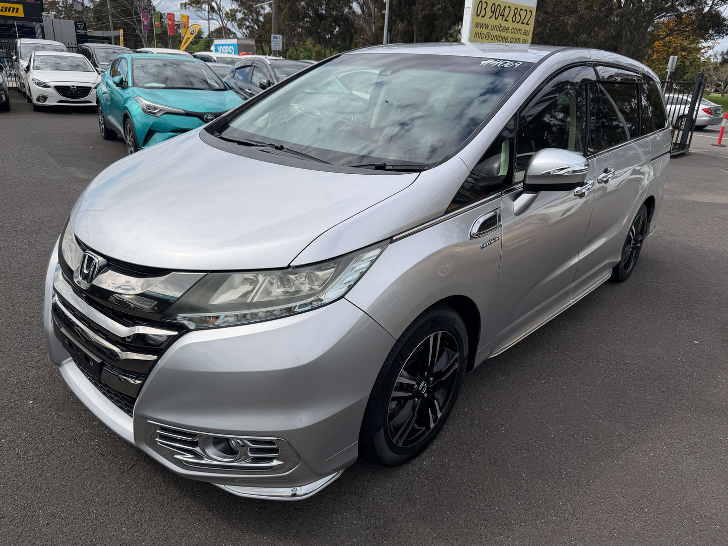 2016 Honda Odyssey 2.0 Hybrid in silver color parked, showcasing sleek design and modern features.