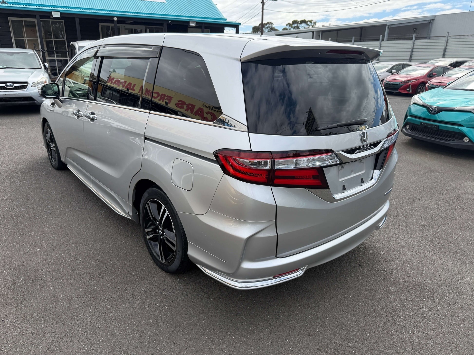 2016 Honda Odyssey 2.0 Hybrid silver minivan exterior view showcasing sleek design and spacious features.