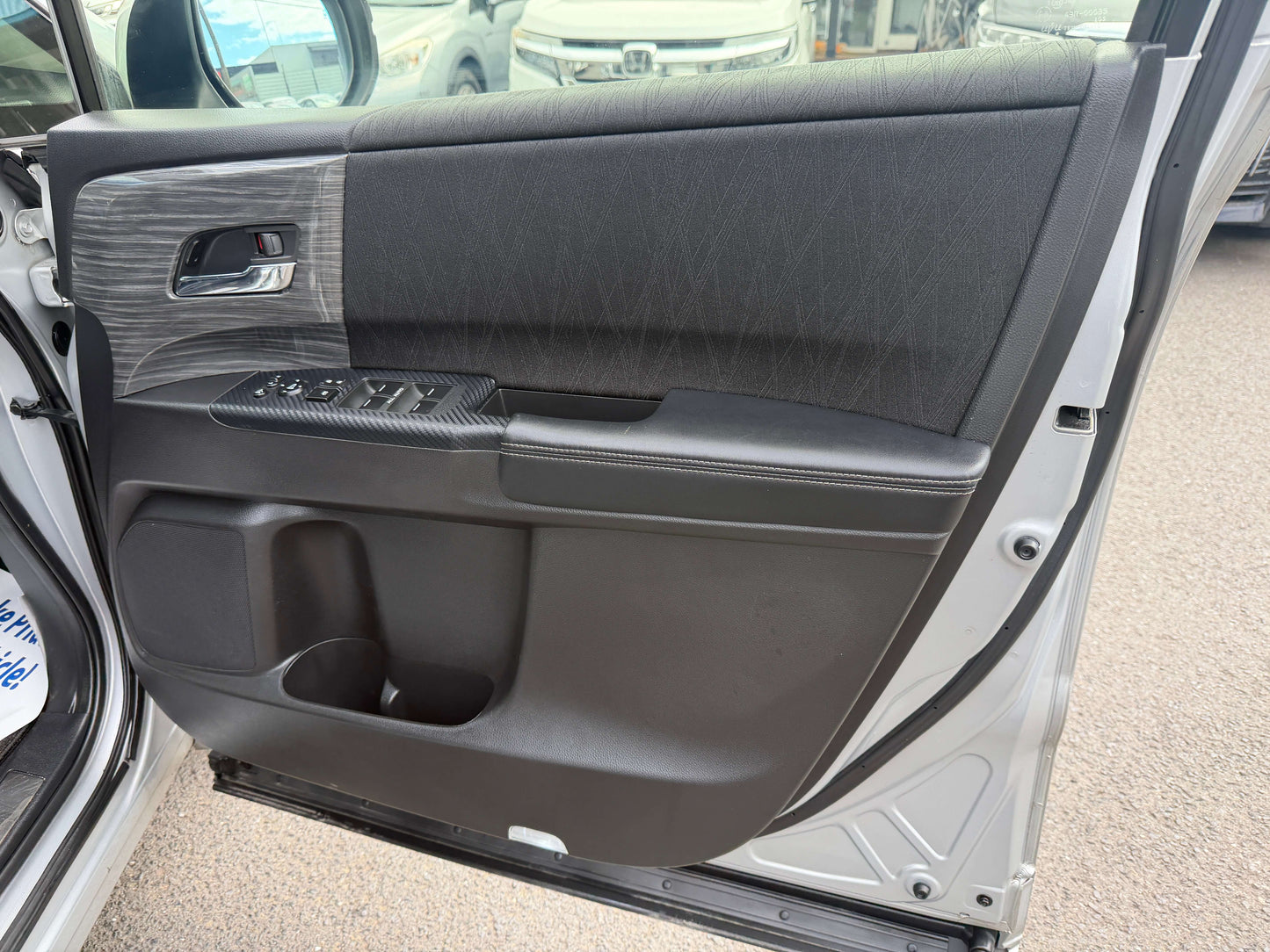 Interior view of the 2016 Honda Odyssey 2.0 Hybrid door panel showcasing luxury design and features.