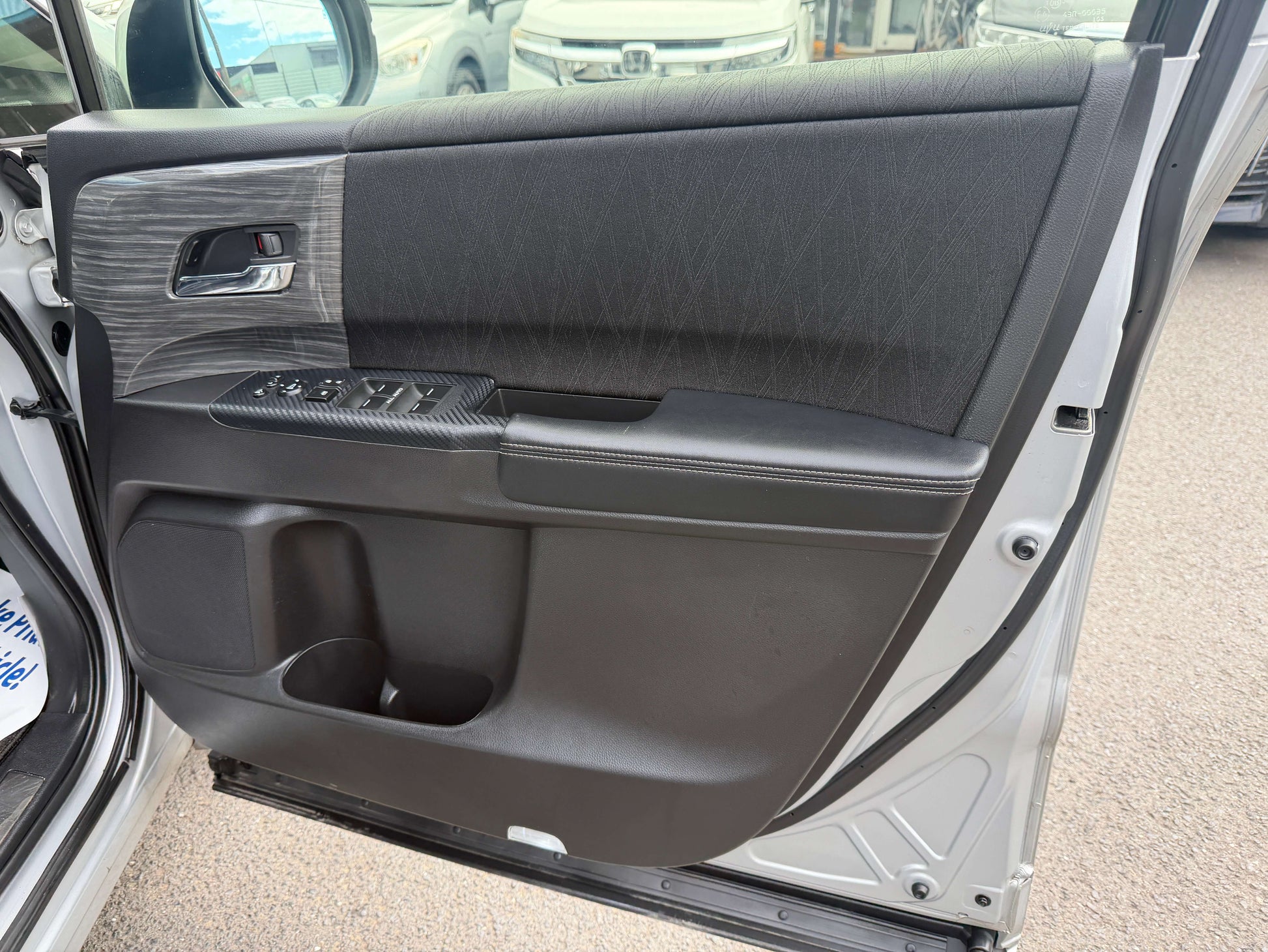 Interior view of the 2016 Honda Odyssey 2.0 Hybrid door panel showcasing luxury design and features.