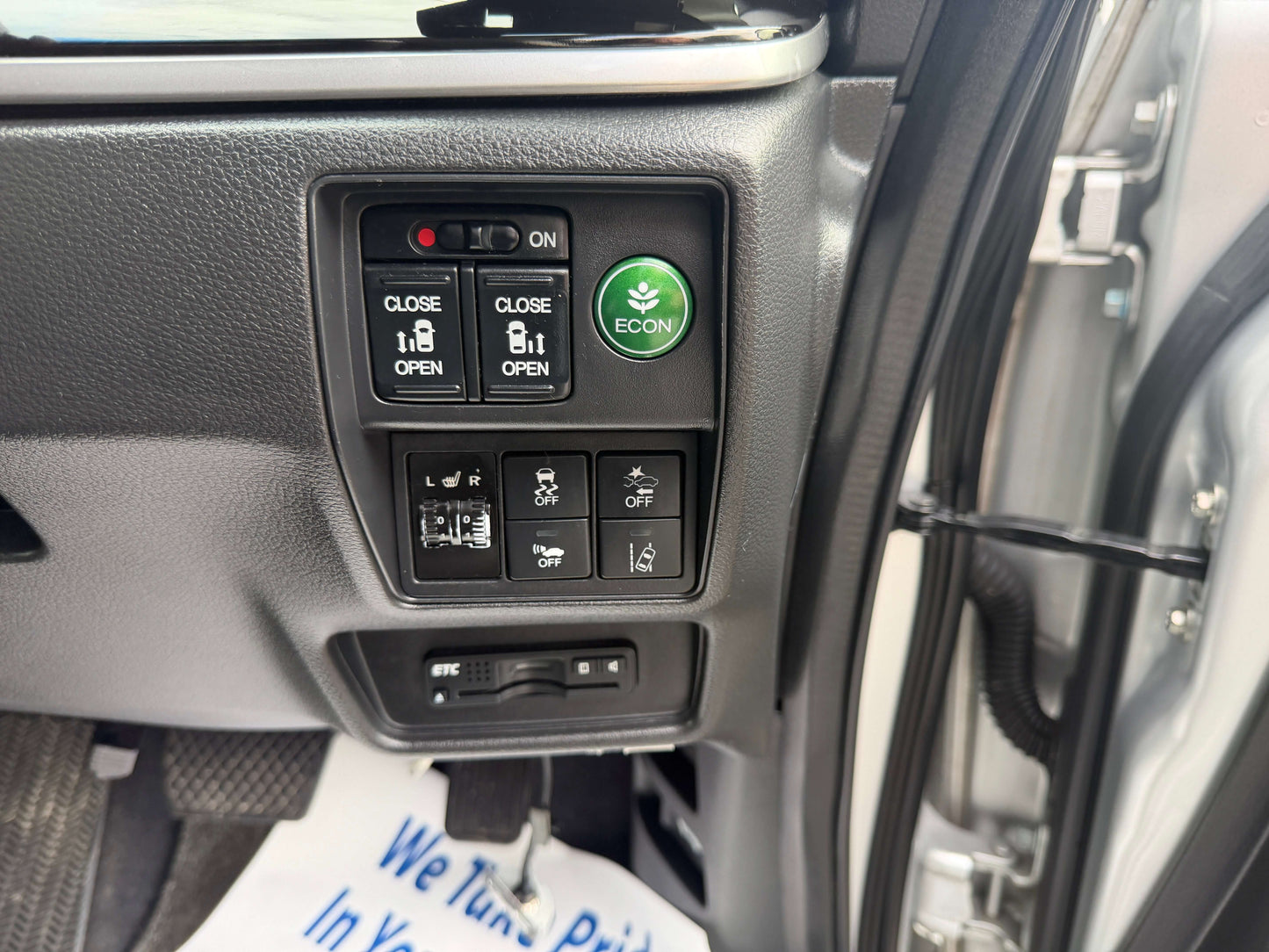 Interior controls of a 2016 Honda Odyssey 2.0 Hybrid with ECON button and window switches.