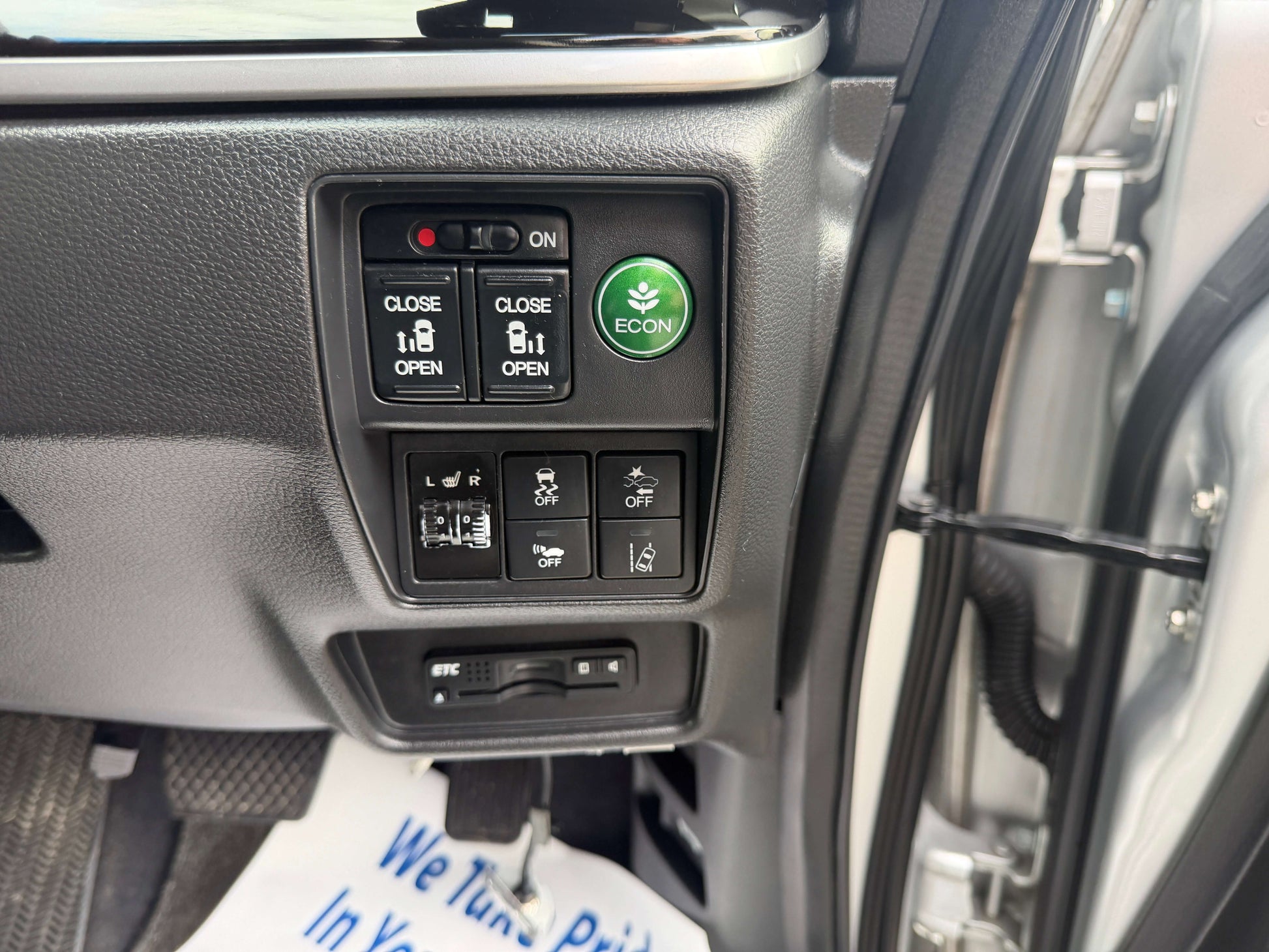 Interior controls of a 2016 Honda Odyssey 2.0 Hybrid with ECON button and window switches.