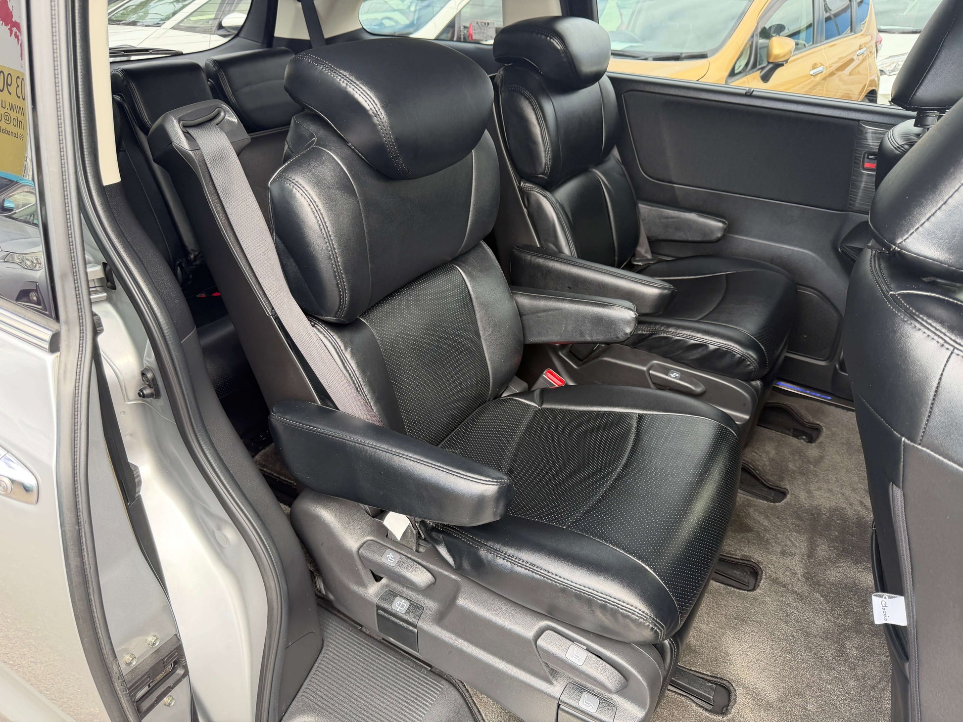 Interior view of black leather seats in 2016 Honda Odyssey 2.0 Hybrid, highlighting space and comfort for family travel.