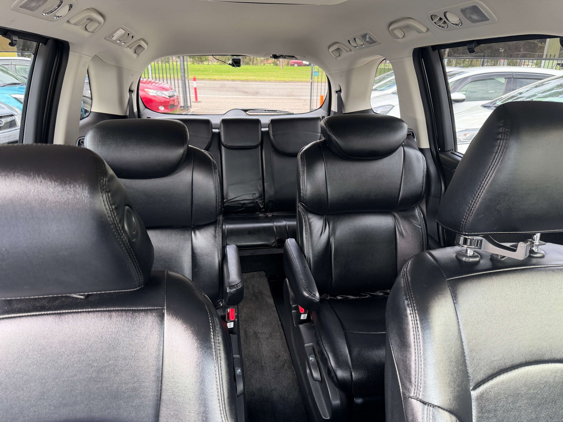 Interior view of 2016 Honda Odyssey 2.0 Hybrid with spacious black leather seating for seven passengers.
