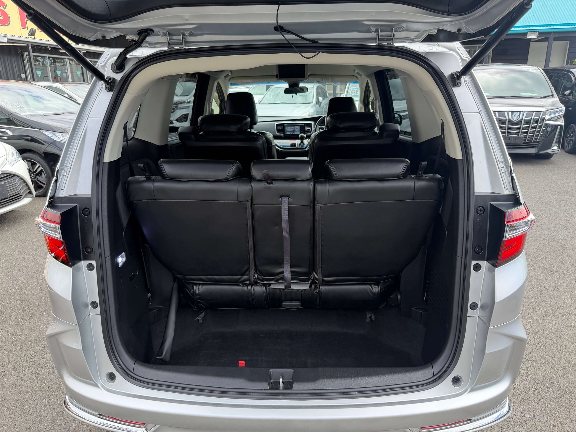 Interior view of the spacious rear seating area in a 2016 Honda Odyssey 2.0 Hybrid with leather seats.