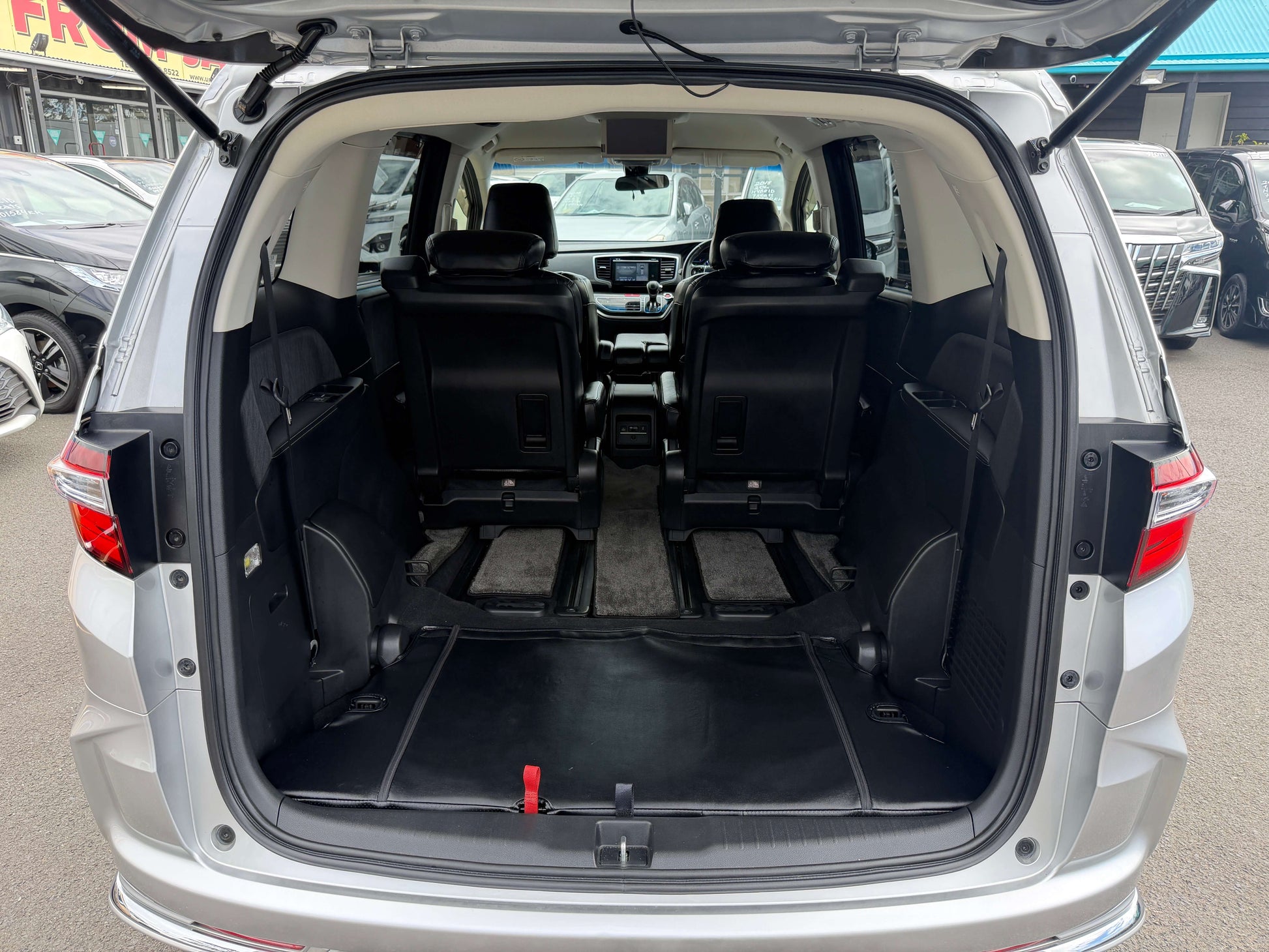 2016 Honda Odyssey 2.0 Hybrid rear interior view showcasing spacious seating and cargo area for family travel.