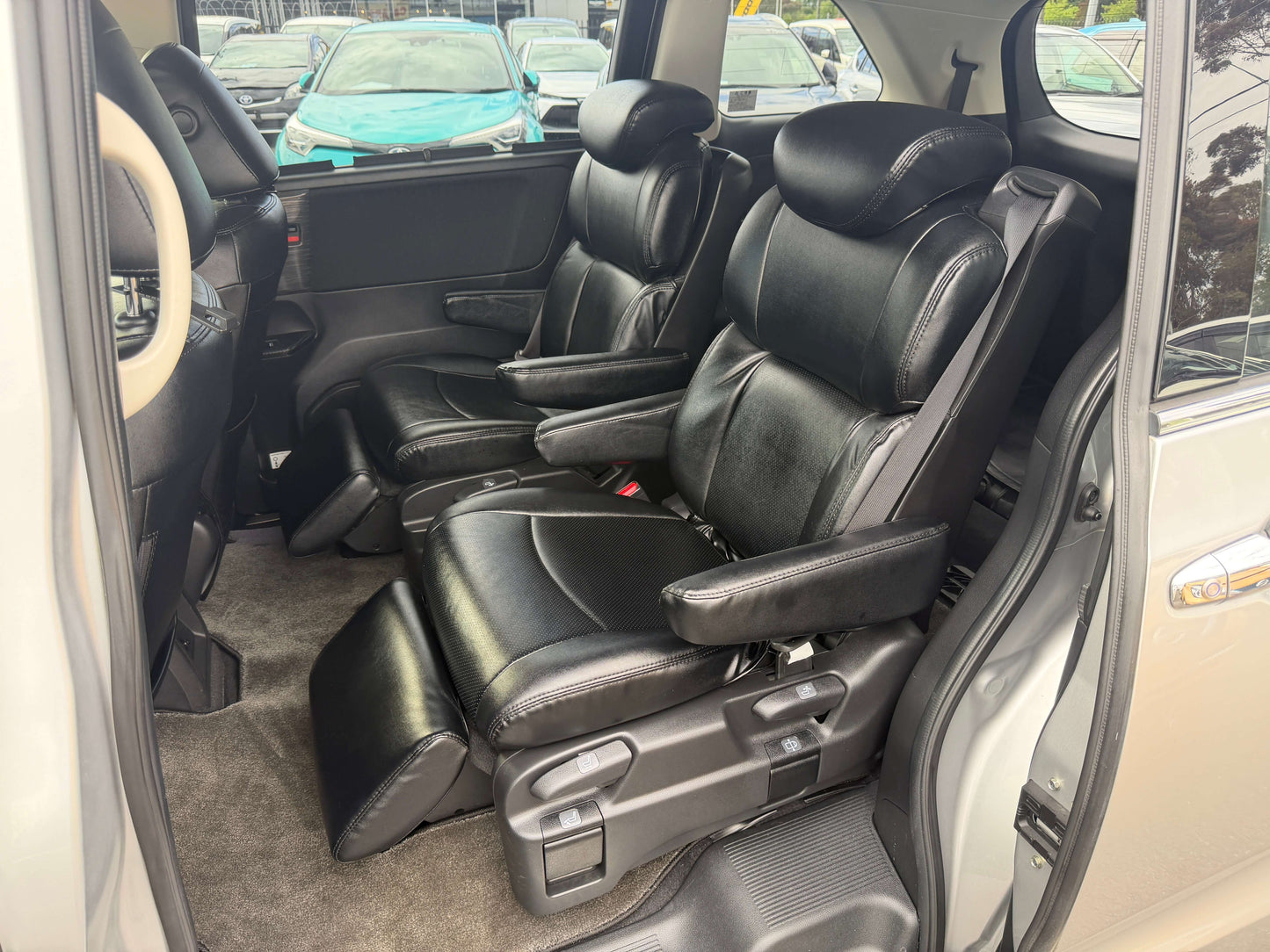 Interior view of the 2016 Honda Odyssey 2.0 Hybrid with black leather seats and spacious seating for 7 passengers.