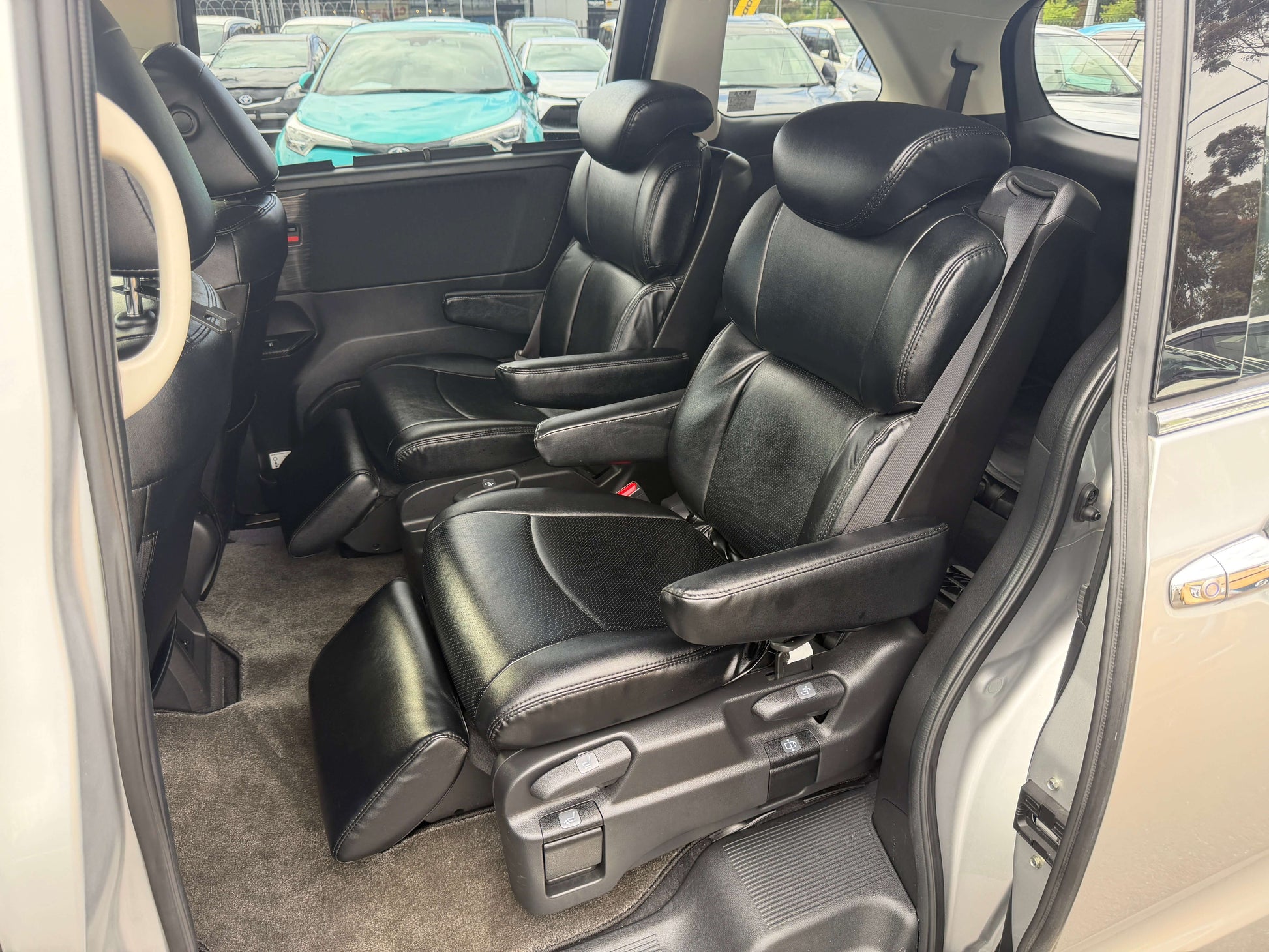 Interior view of the 2016 Honda Odyssey 2.0 Hybrid with black leather seats and spacious seating for 7 passengers.