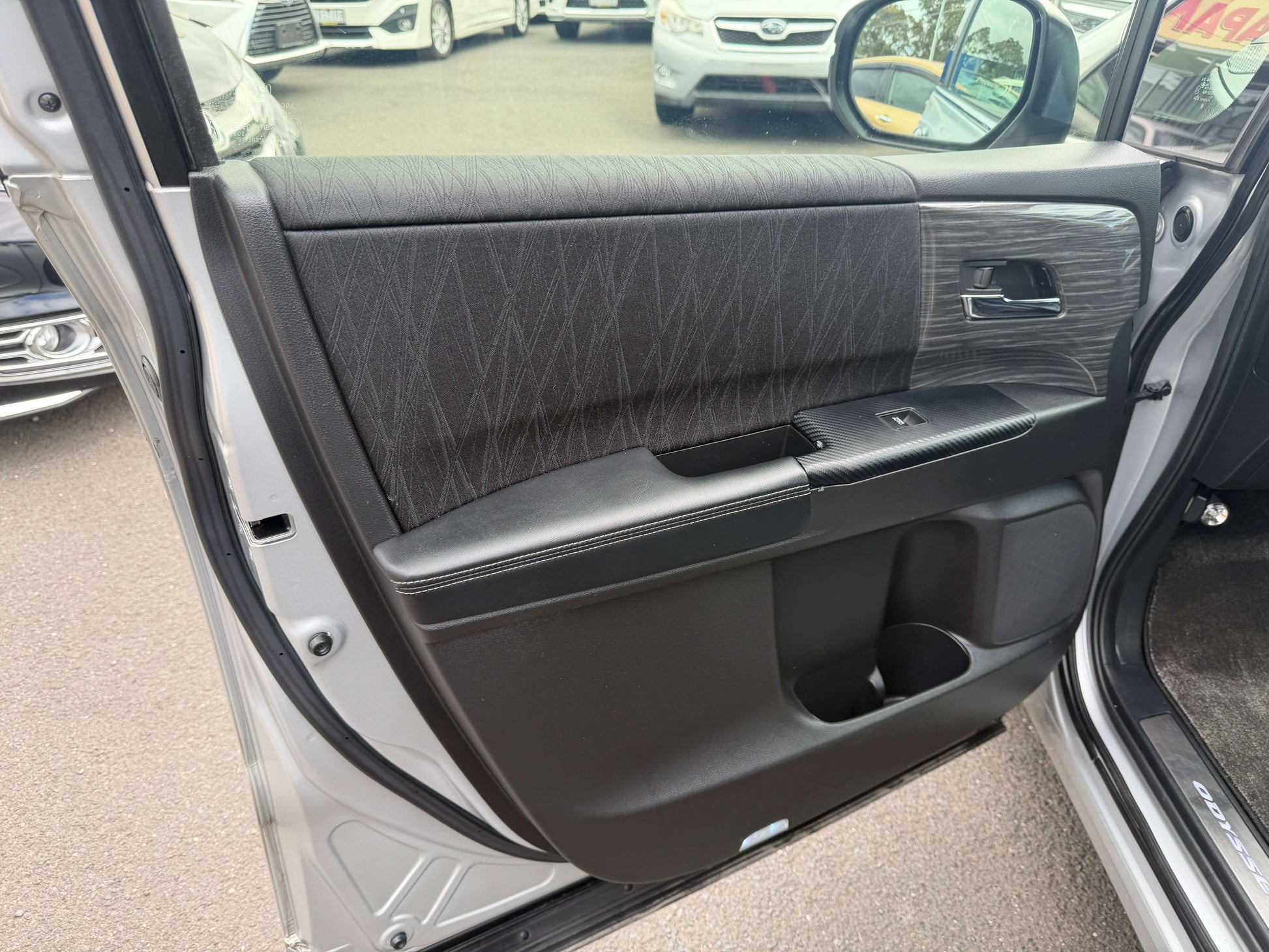 Interior view of the door panel of a 2016 Honda Odyssey 2.0 Hybrid showing luxury features and design.