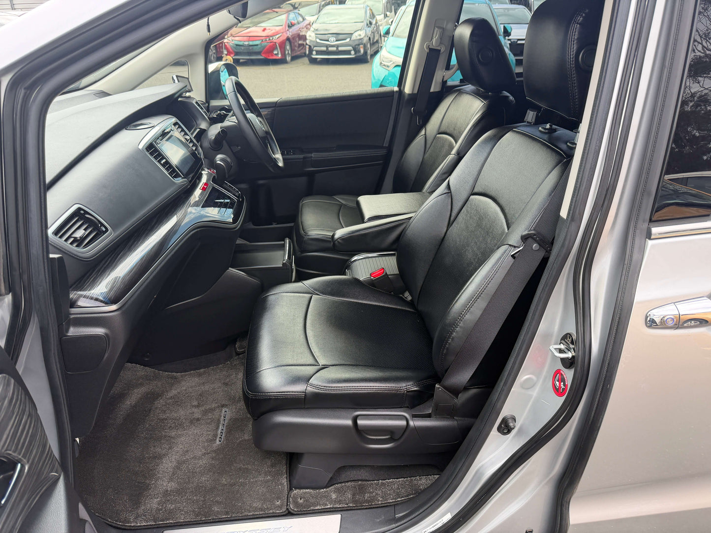 Interior view of 2016 Honda Odyssey 2.0 Hybrid with spacious black leather seating for driver and passenger.