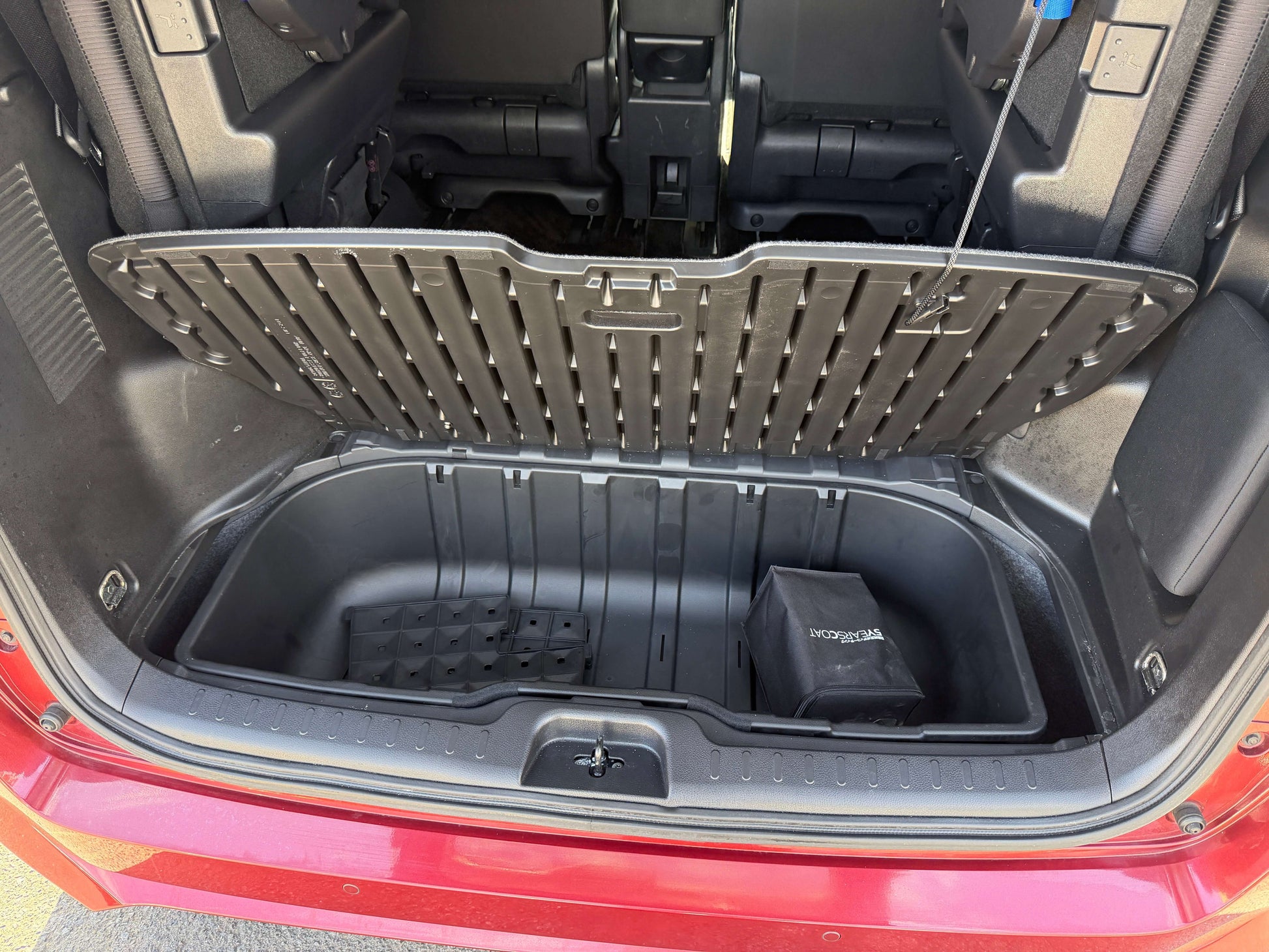 2016 Nissan Serena 2.0L S-Hybrid cargo space with underfloor storage compartment and lid open.