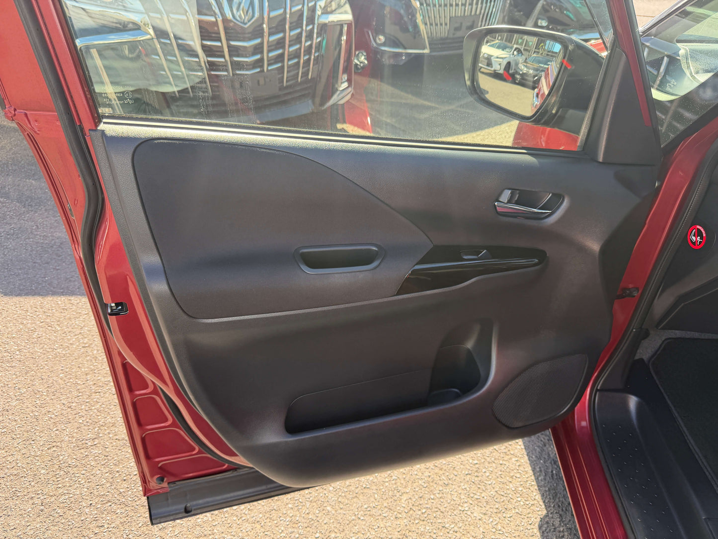 2016 Nissan Serena 2.0L S-Hybrid black interior door panel with handle, showcasing modern design features.