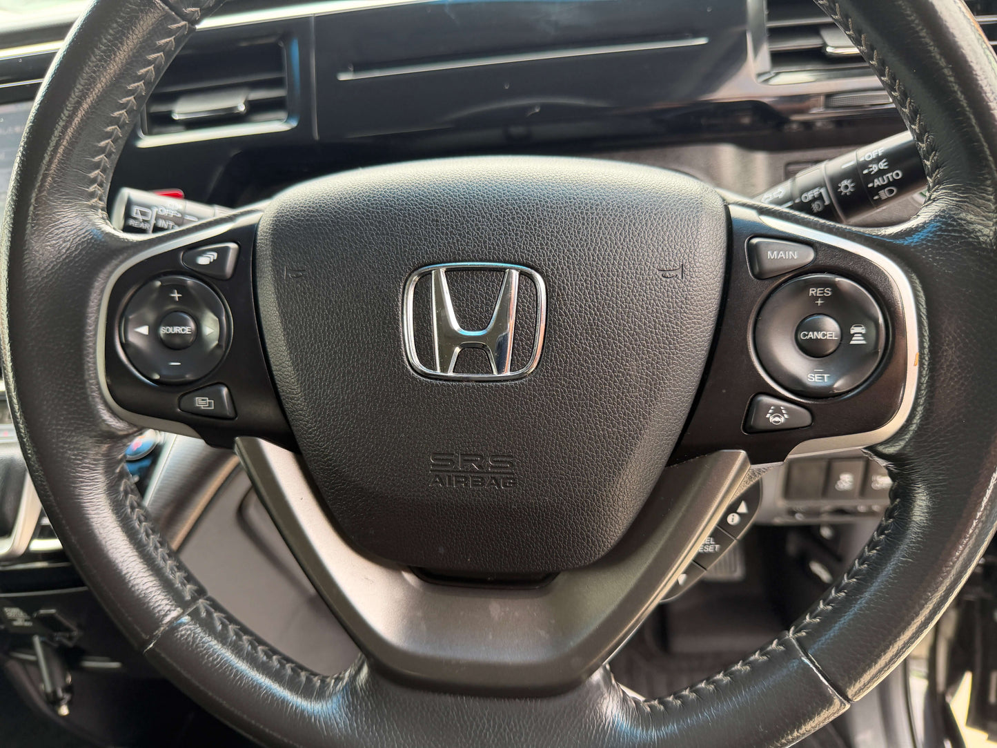 Steering wheel of a 2018 Honda Stepwgn 2.0 Spada Hybrid G Honda Sensing with controls and Honda logo.