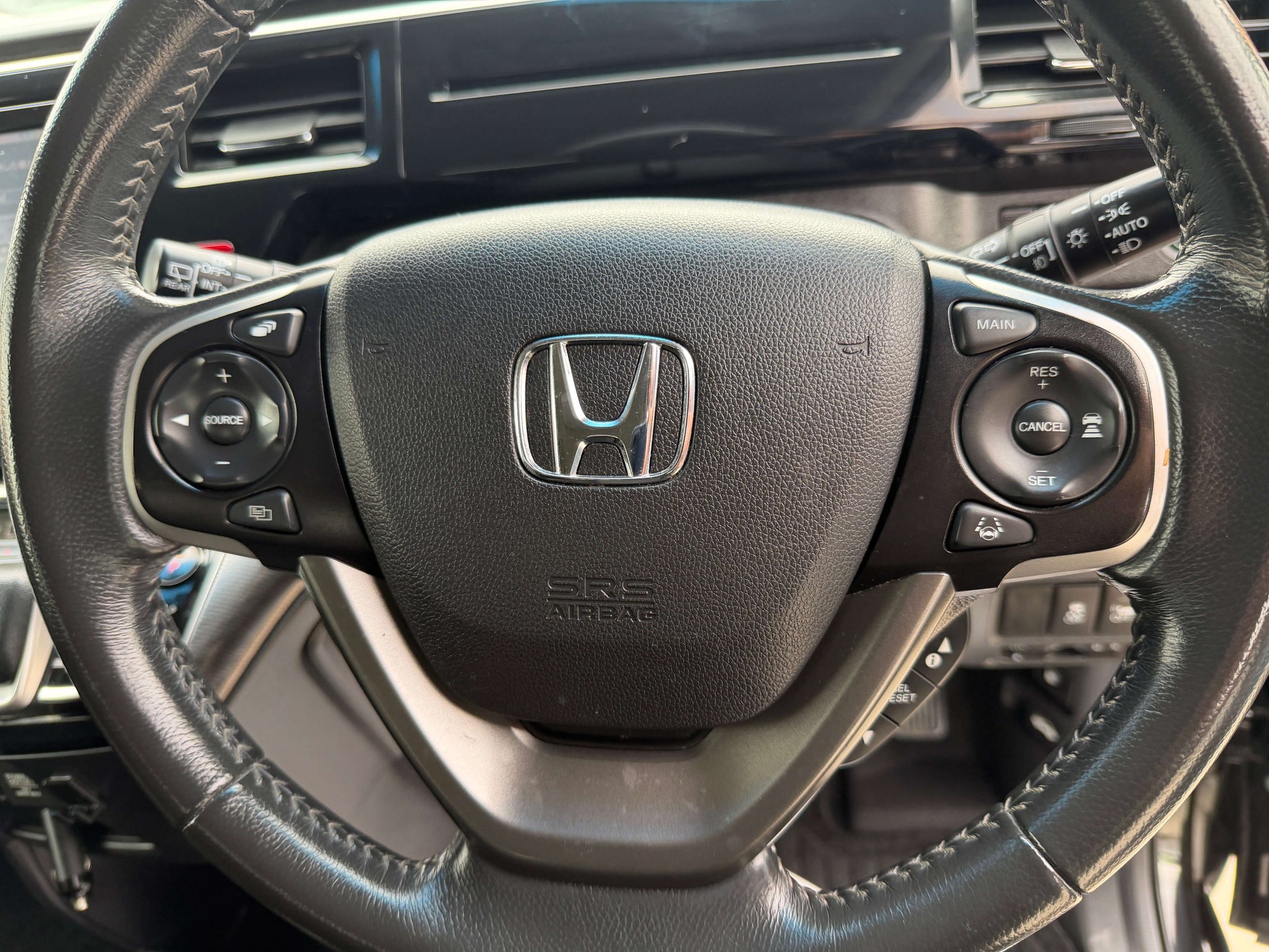 Steering wheel of a 2018 Honda Stepwgn 2.0 Spada Hybrid G Honda Sensing with controls and Honda logo.