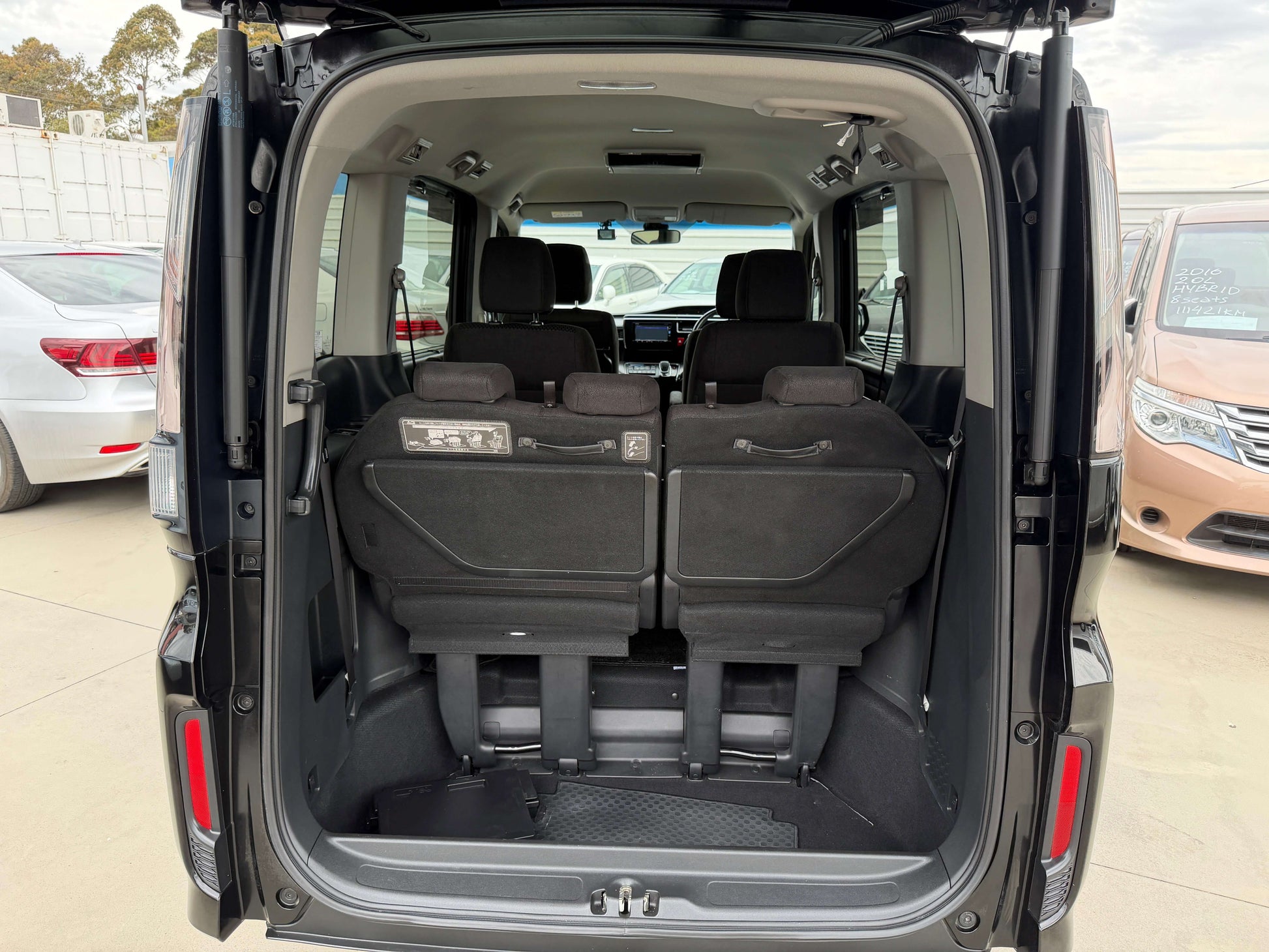 Interior view of the rear seating area in a 2018 Honda Stepwgn 2.0 Spada Hybrid, showcasing spacious seating for a family.