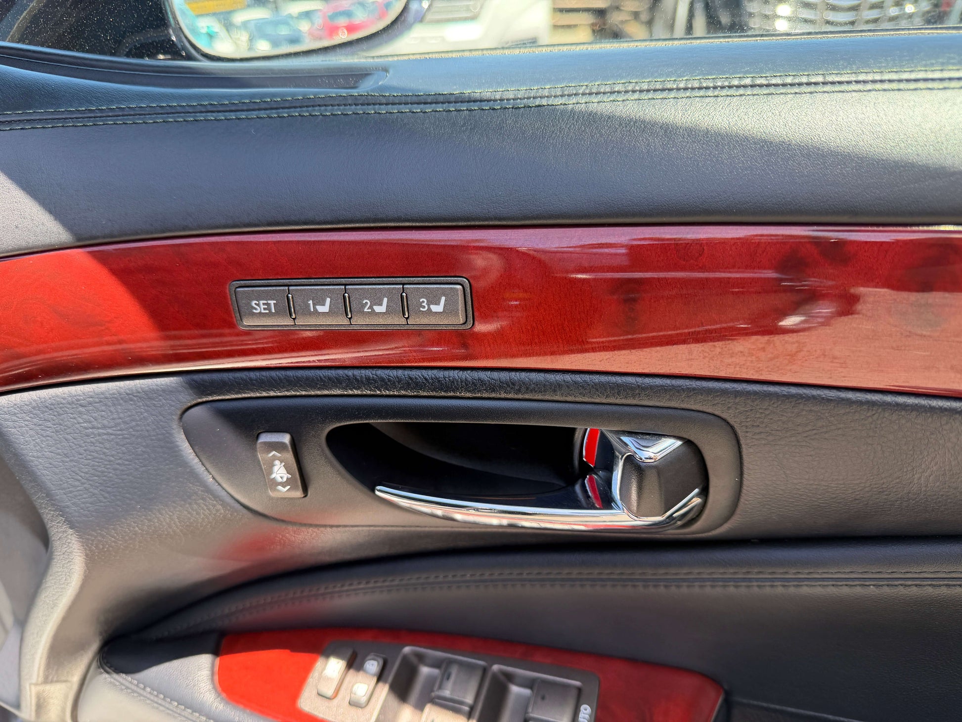 Interior door panel of 2007 Lexus LS600hL AWD V8 5.0L Hybrid featuring adjustment controls and wood trim.