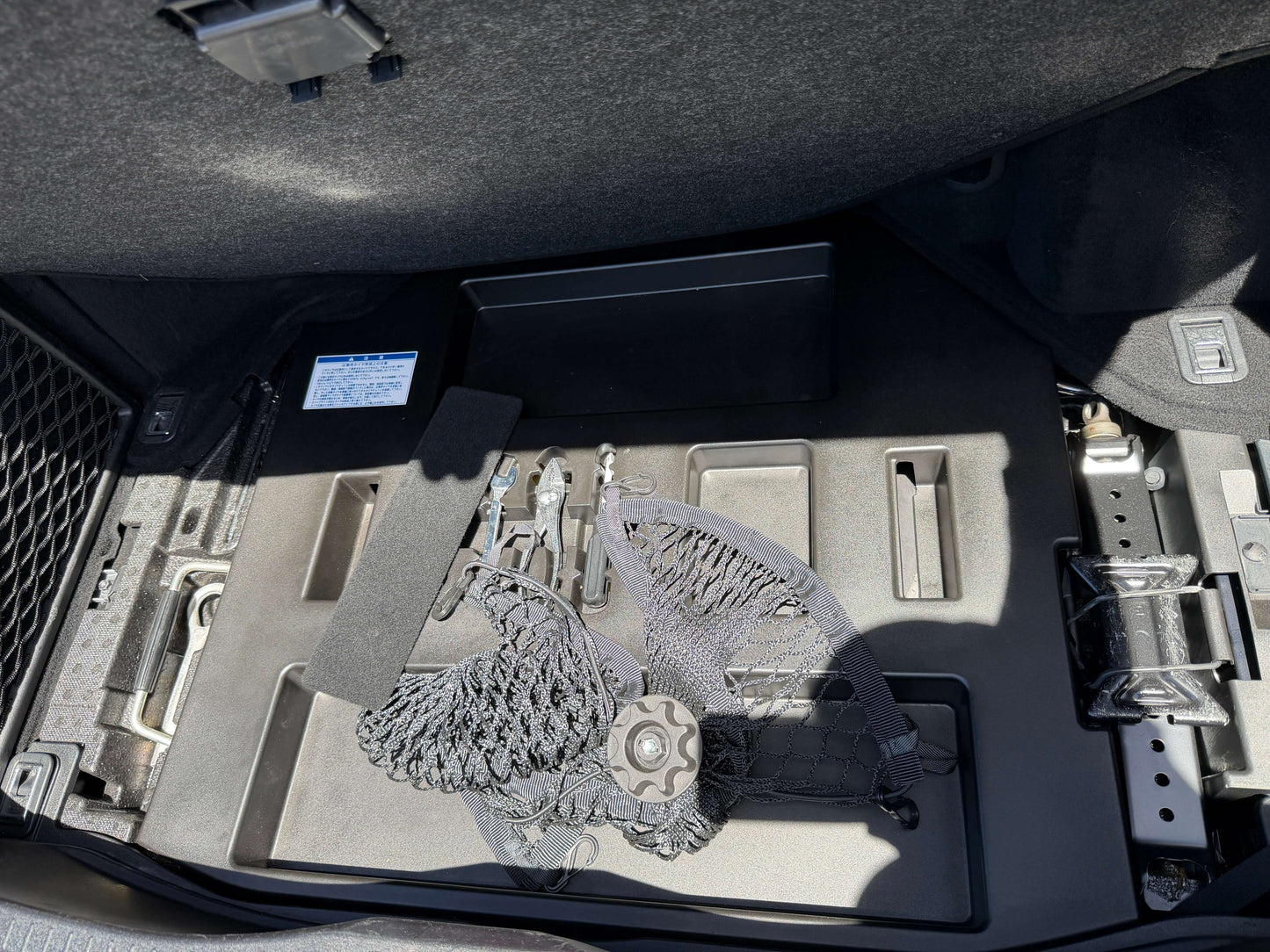 Interior view of the 2007 Lexus LS600hL AWD V8 5.0L Hybrid trunk showing tools and components.
