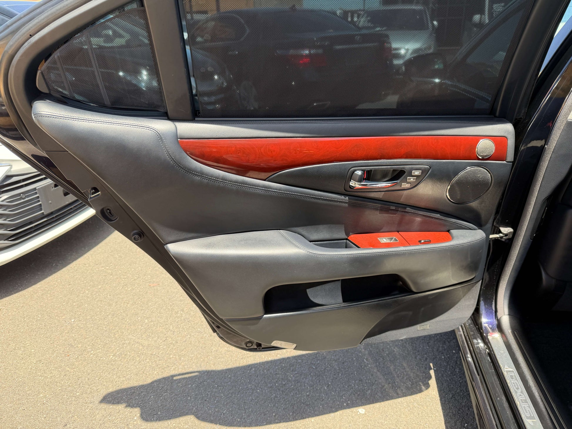 Interior door panel of a 2007 Lexus LS600hL AWD V8 5.0L Hybrid Luxury Sedan showing wood trim and controls.