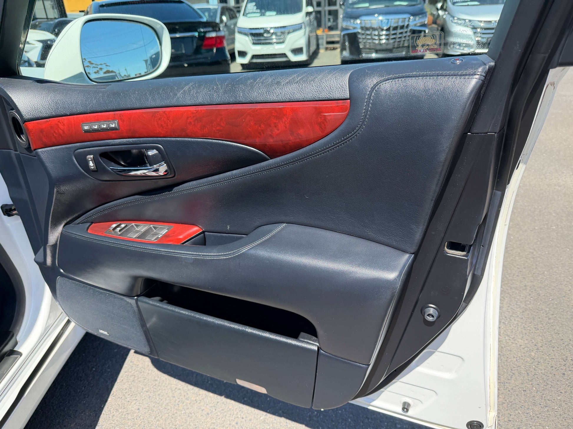 Interior door panel of a 2007 Lexus LS600h AWD V8 5.0L Hybrid Luxury Sedan showing leather and wood trim.