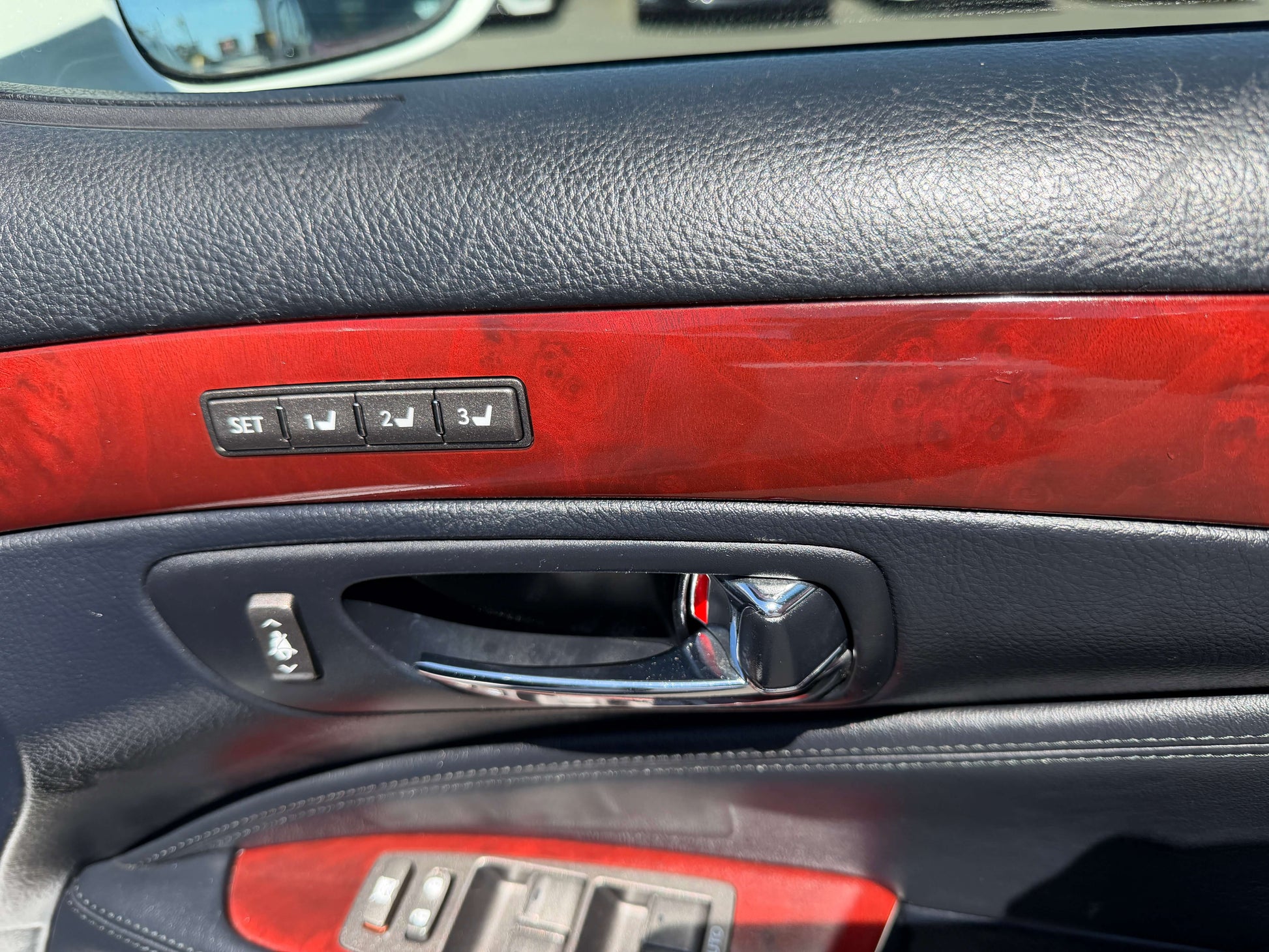 Interior door controls of a 2007 Lexus LS600h AWD V8 5.0L Hybrid Luxury Sedan with wood accents.